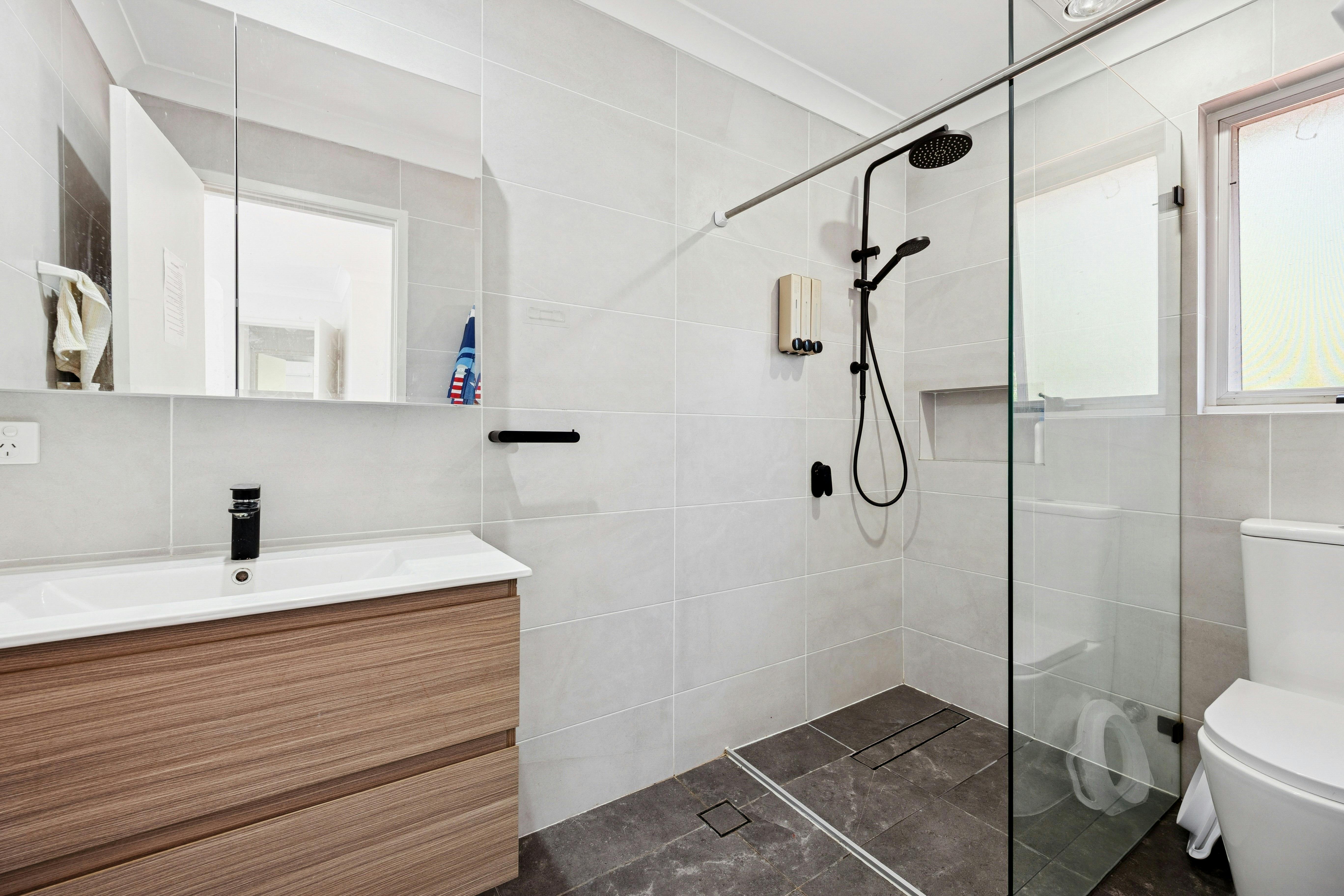 Modern bathroom with vanity, toilet, and glass-enclosed shower.