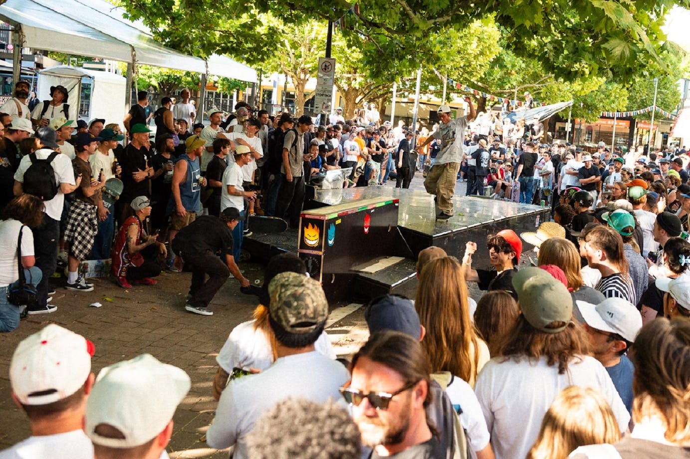 Skateboarder performs nose manual in front of crowd in Canberra city