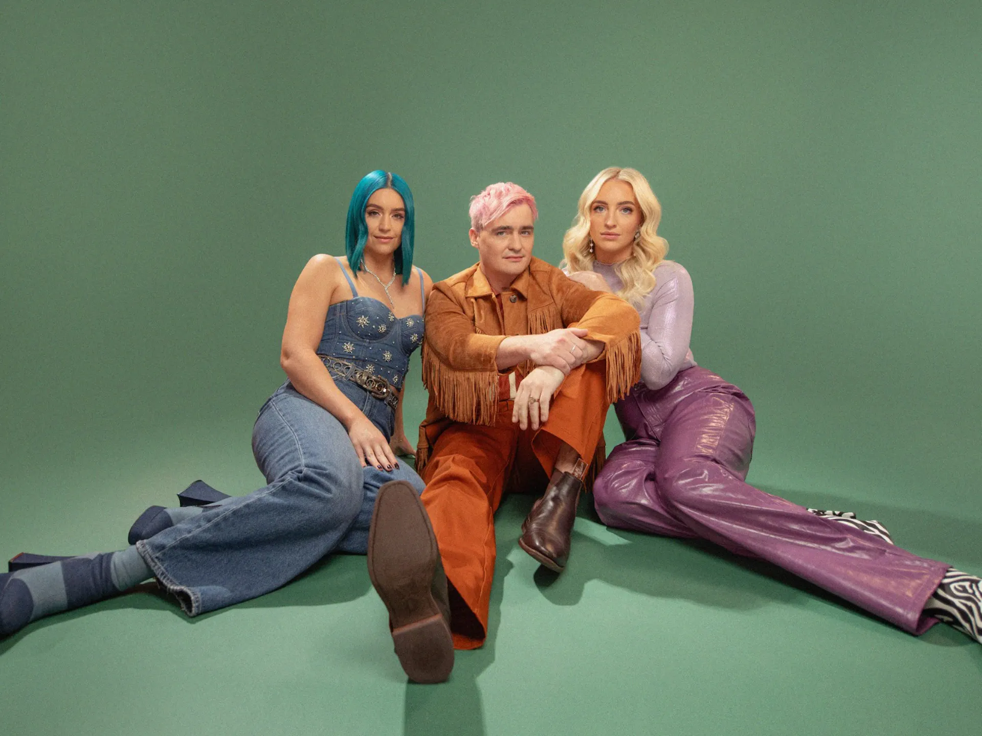 The three members of Sheppard in front of a green background. Studio shot.