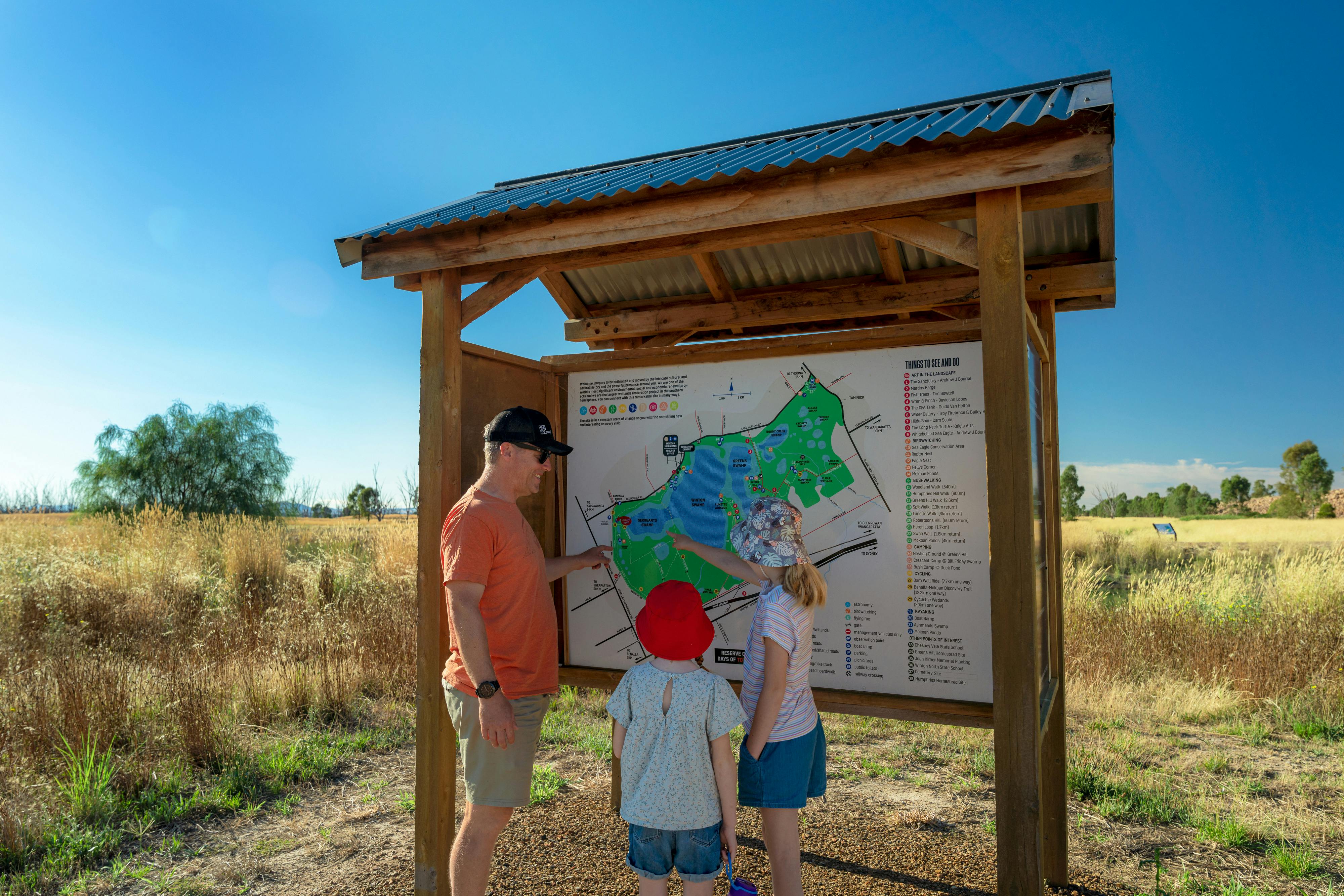 man and two children looking at a map
