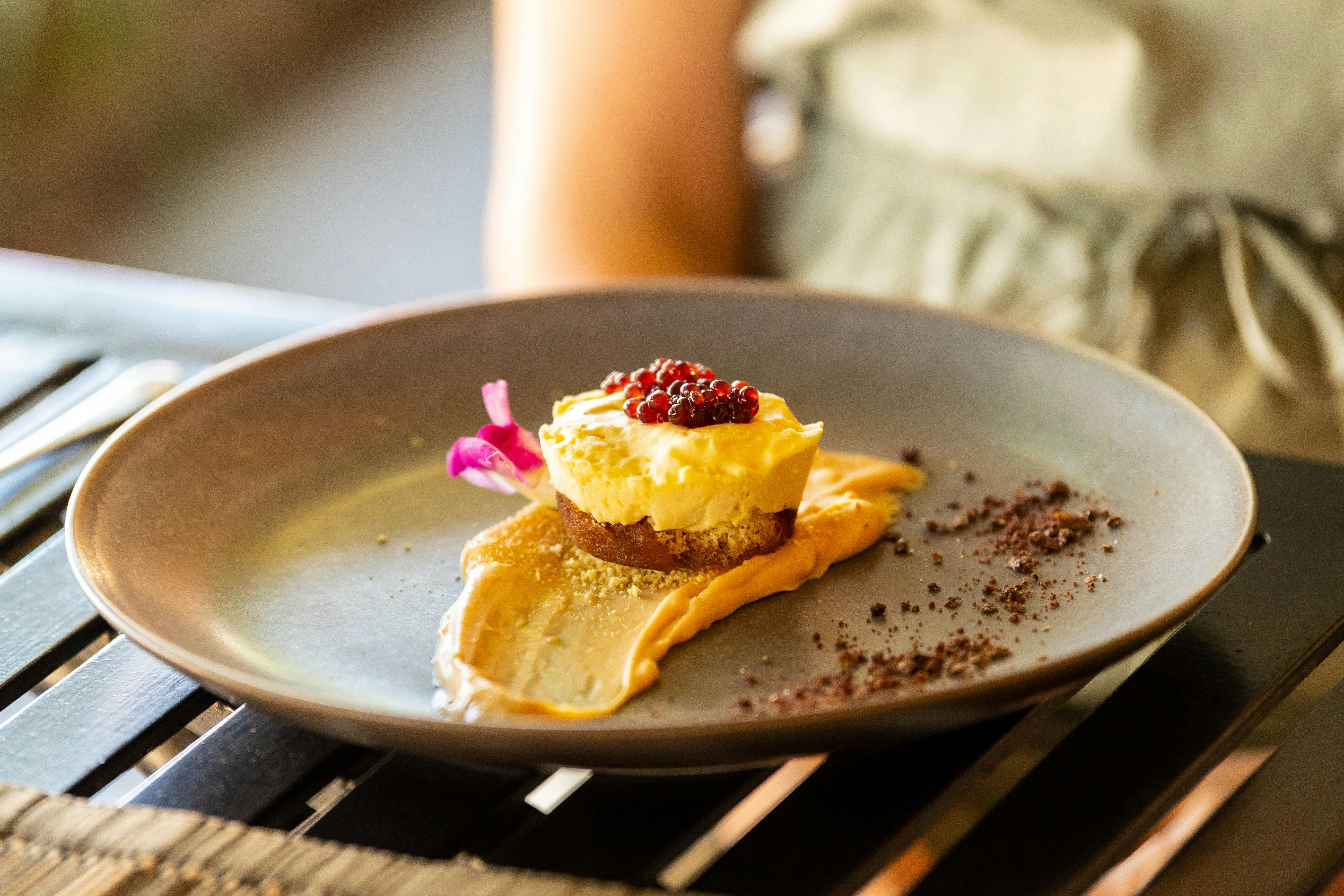 Espresso semifreddo with hazelnut sponge, caramel ganache and Shiraz caviar presented on grey plate