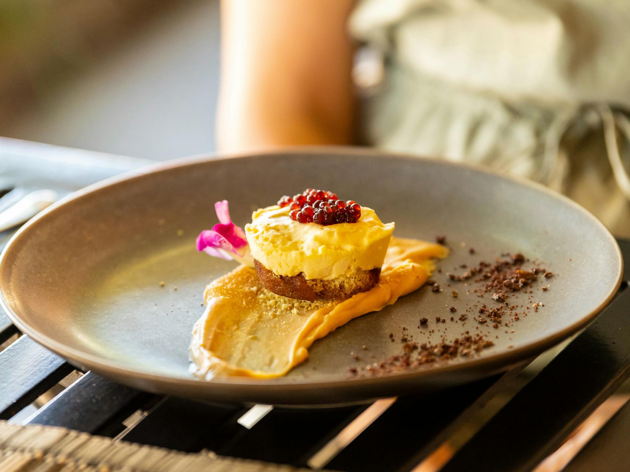 Espresso semifreddo with hazelnut sponge, caramel ganache and Shiraz caviar presented on grey plate