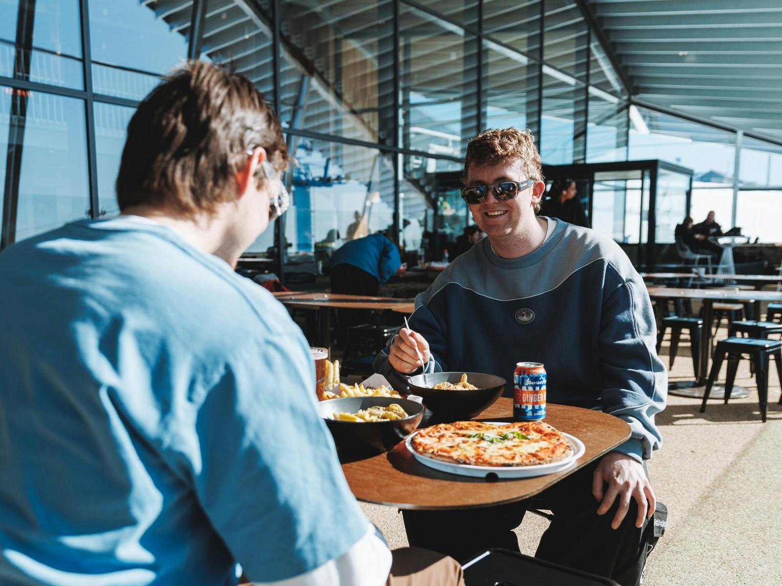 Two friends enjoying pizza and pasta lunch