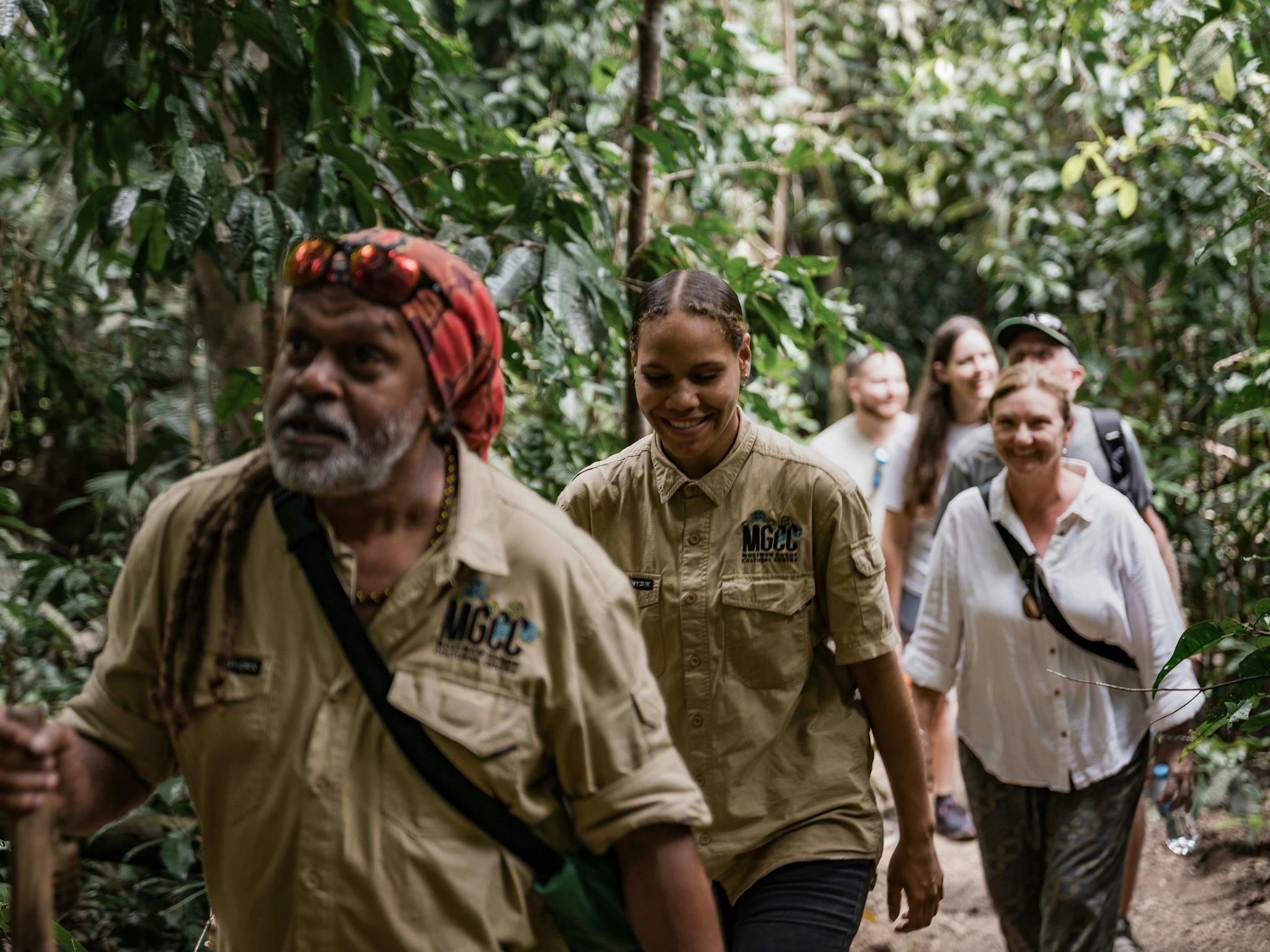 Two tour guides lead a group through Mossman Gorge during the Dreamtime Walk Two tour guides lead a group through Mossman Gorge during the Dreamtime Walk