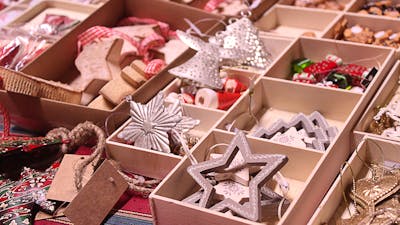 Christmas ornaments in open boxes sitting on a table an a market