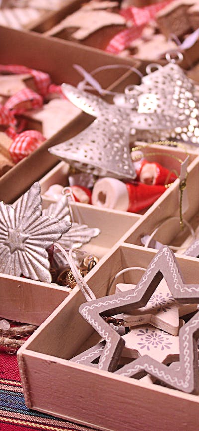 Christmas ornaments in open boxes sitting on a table an a market
