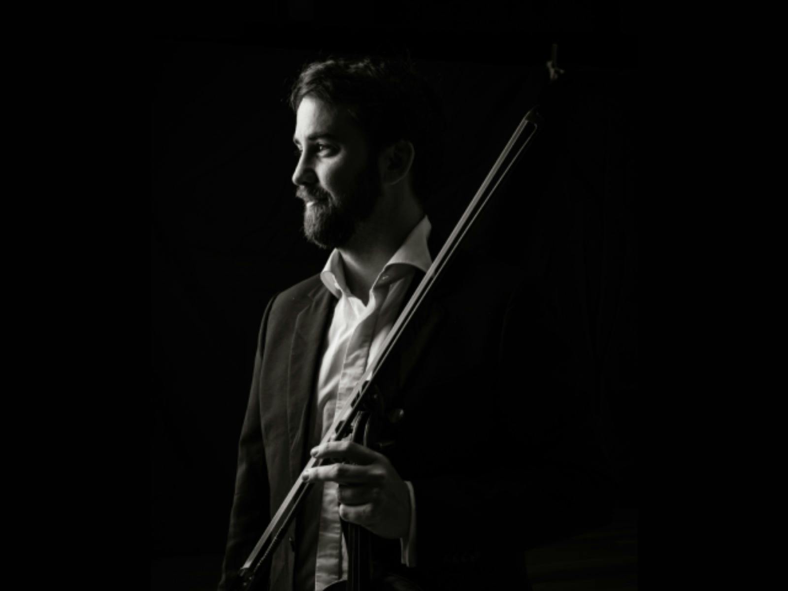 Black-and-white portrait of a violinist in profile, looking toward the light Black-and-white portrait of a violinist in profile, looking toward the light