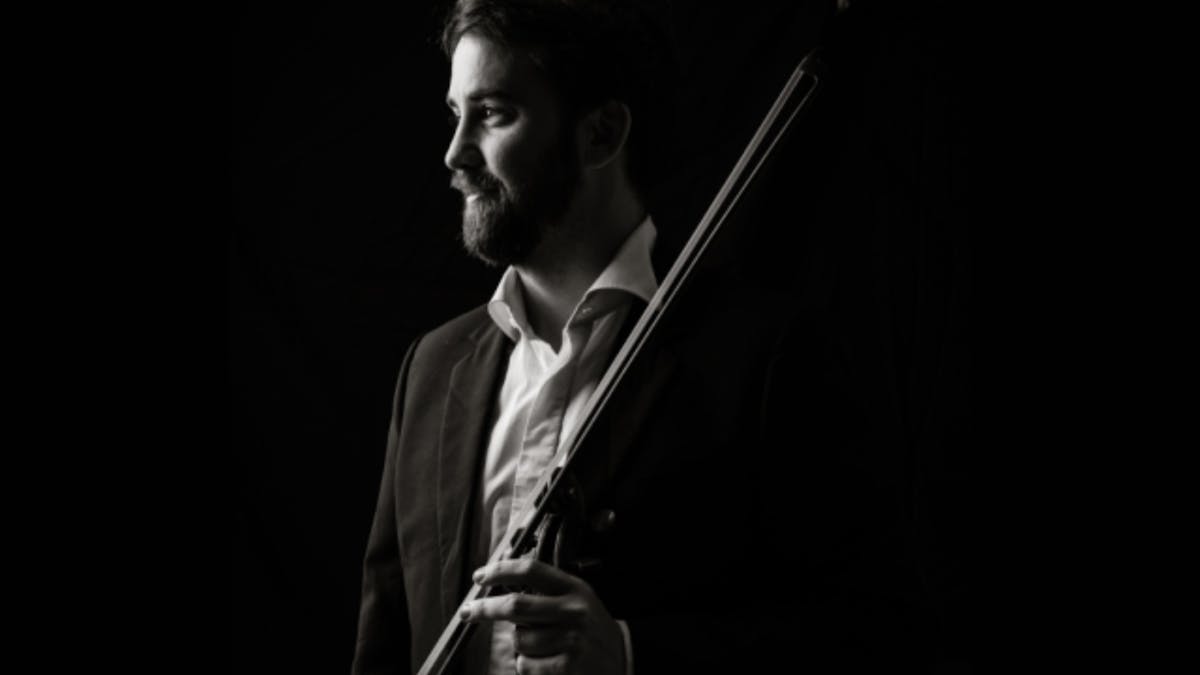 Black-and-white portrait of a violinist in profile, looking toward the light