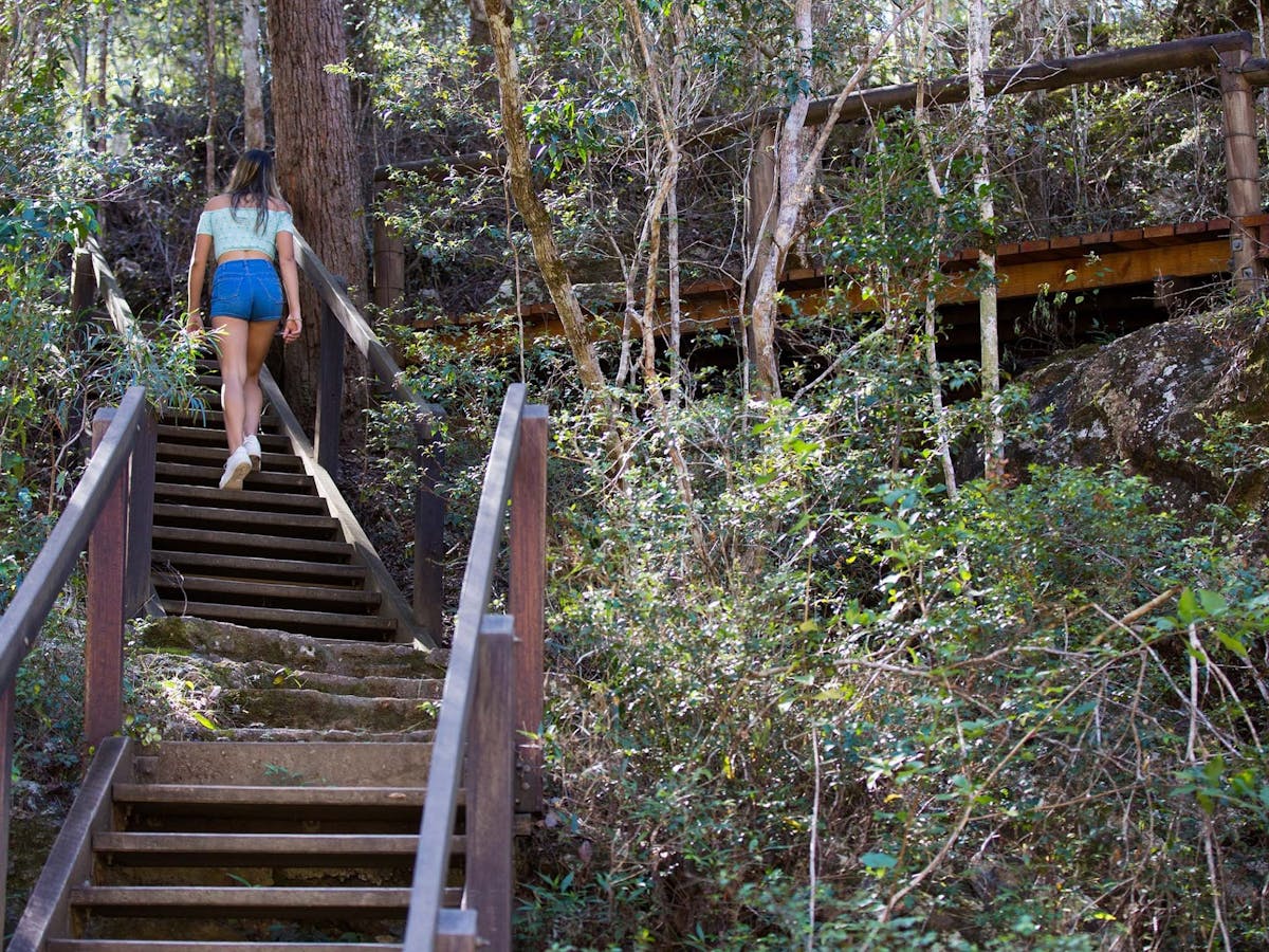 Woman walking up stairs towards Rocky Hole