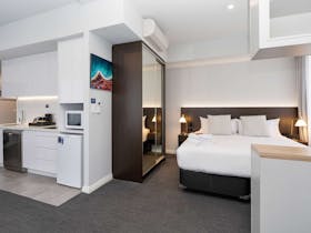 Bedroom & kitchen in Deluxe King Apartment