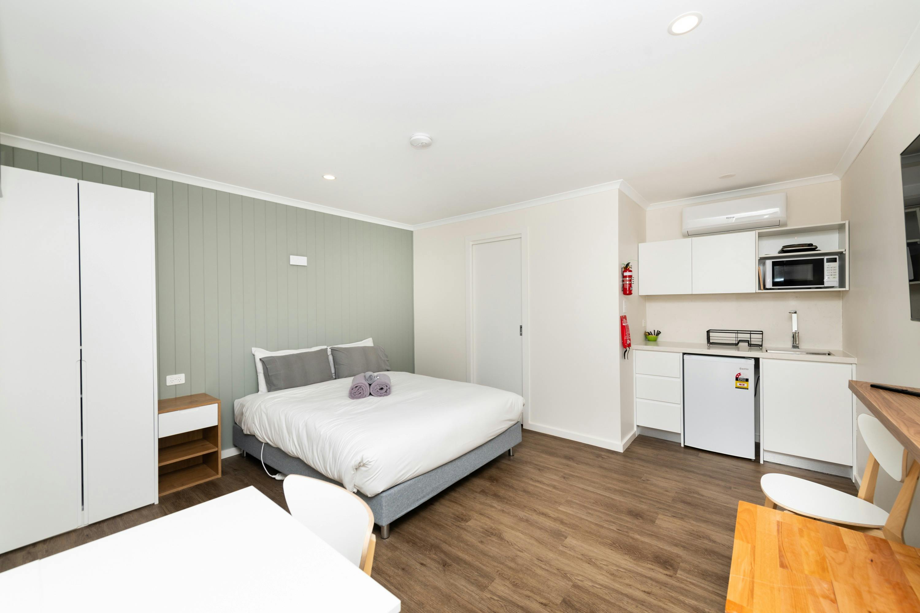 One of the cabins equipped with a mini kitchen, bed and other amenities.