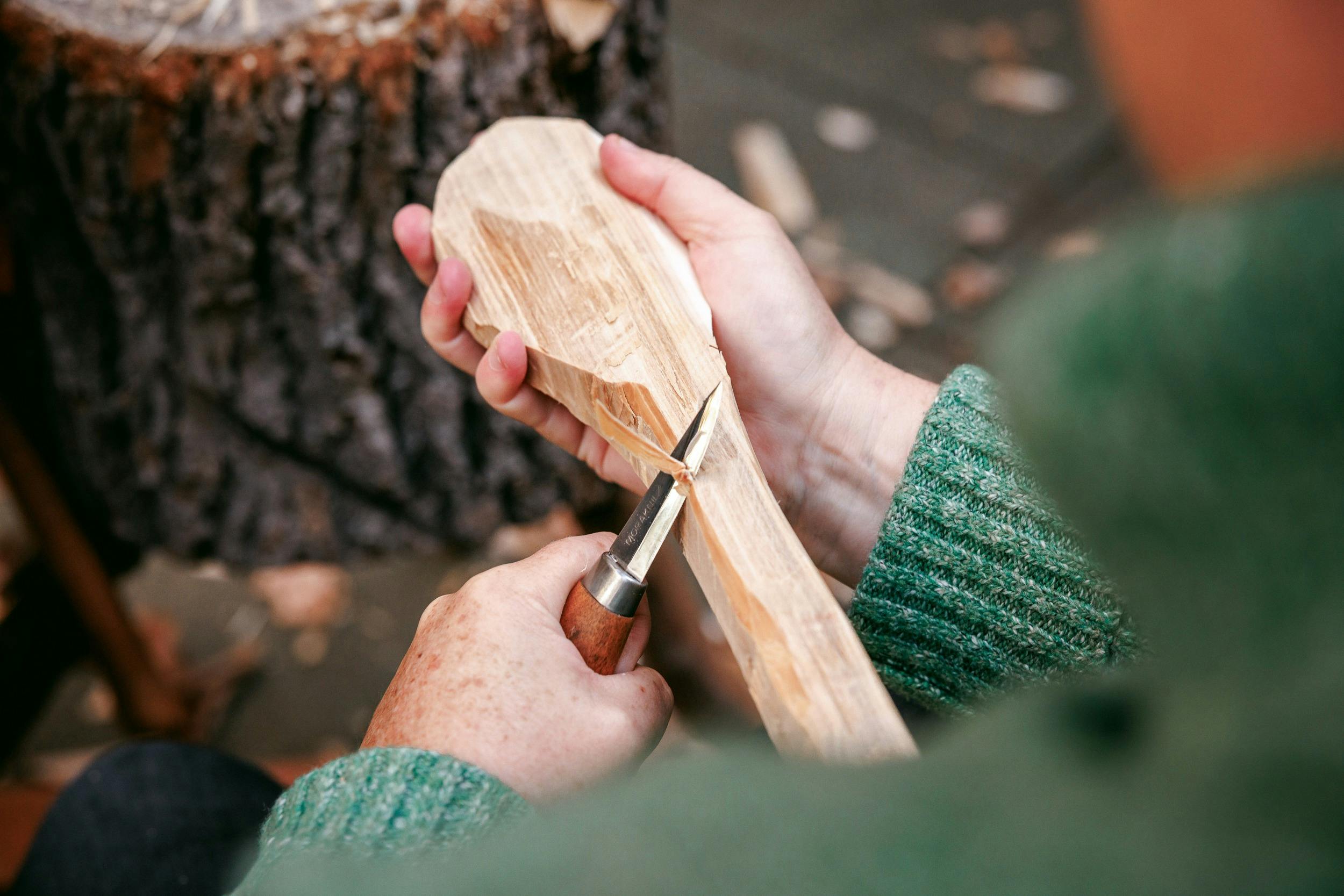a close up of a knife being used to carve a spoon