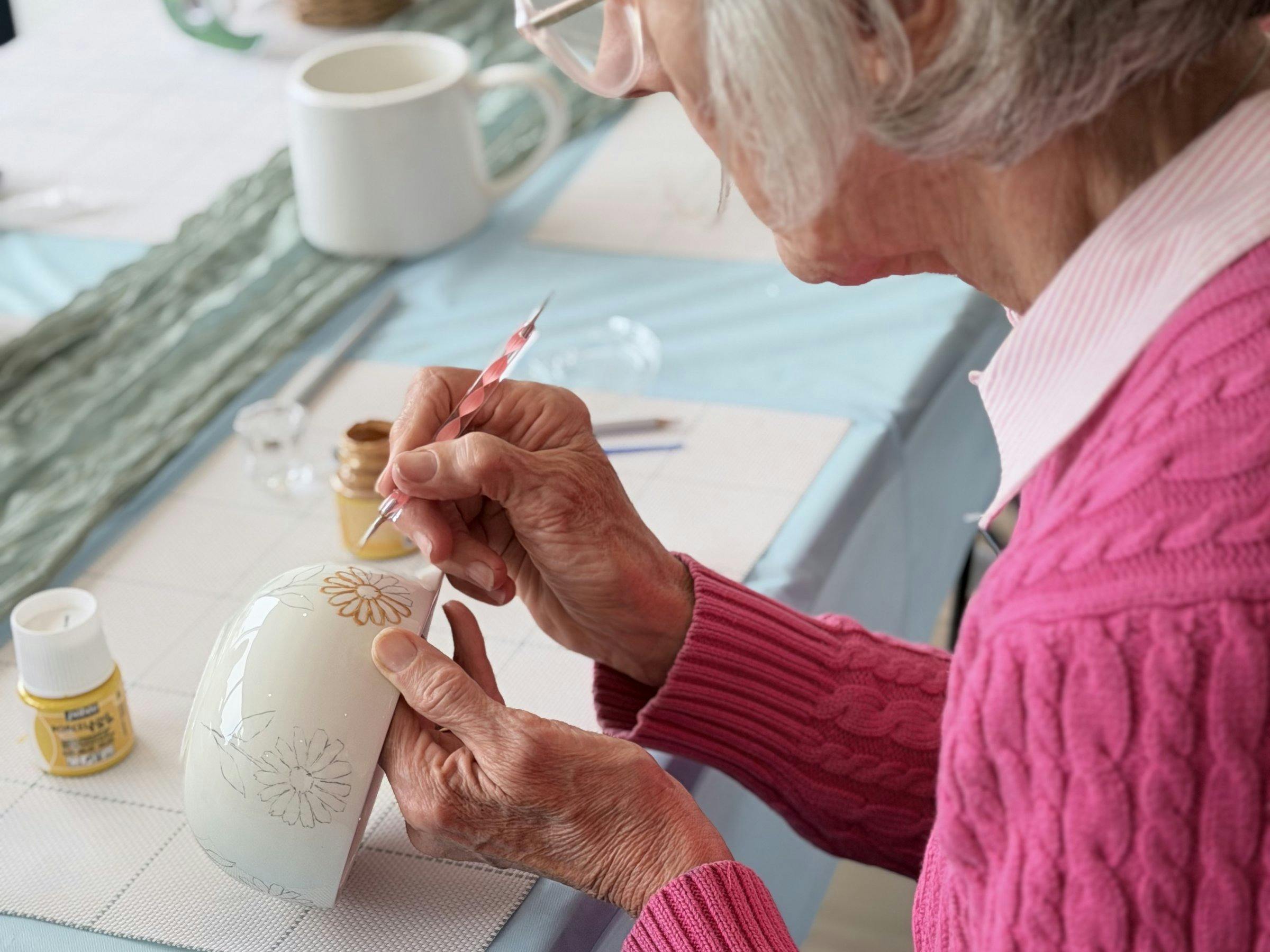Guest hand-painting a ceramic cup at a NOA Matcha workshop