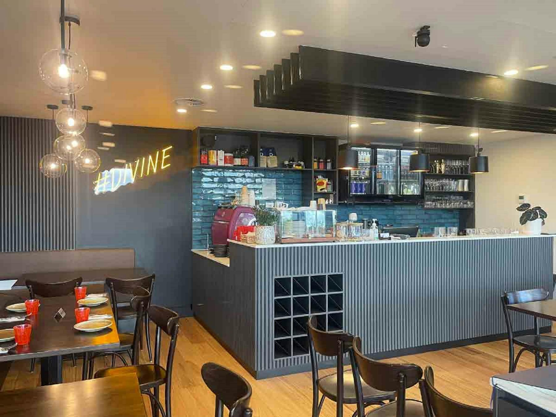 Internal view of empty restaurant with yellow Divine light on wall