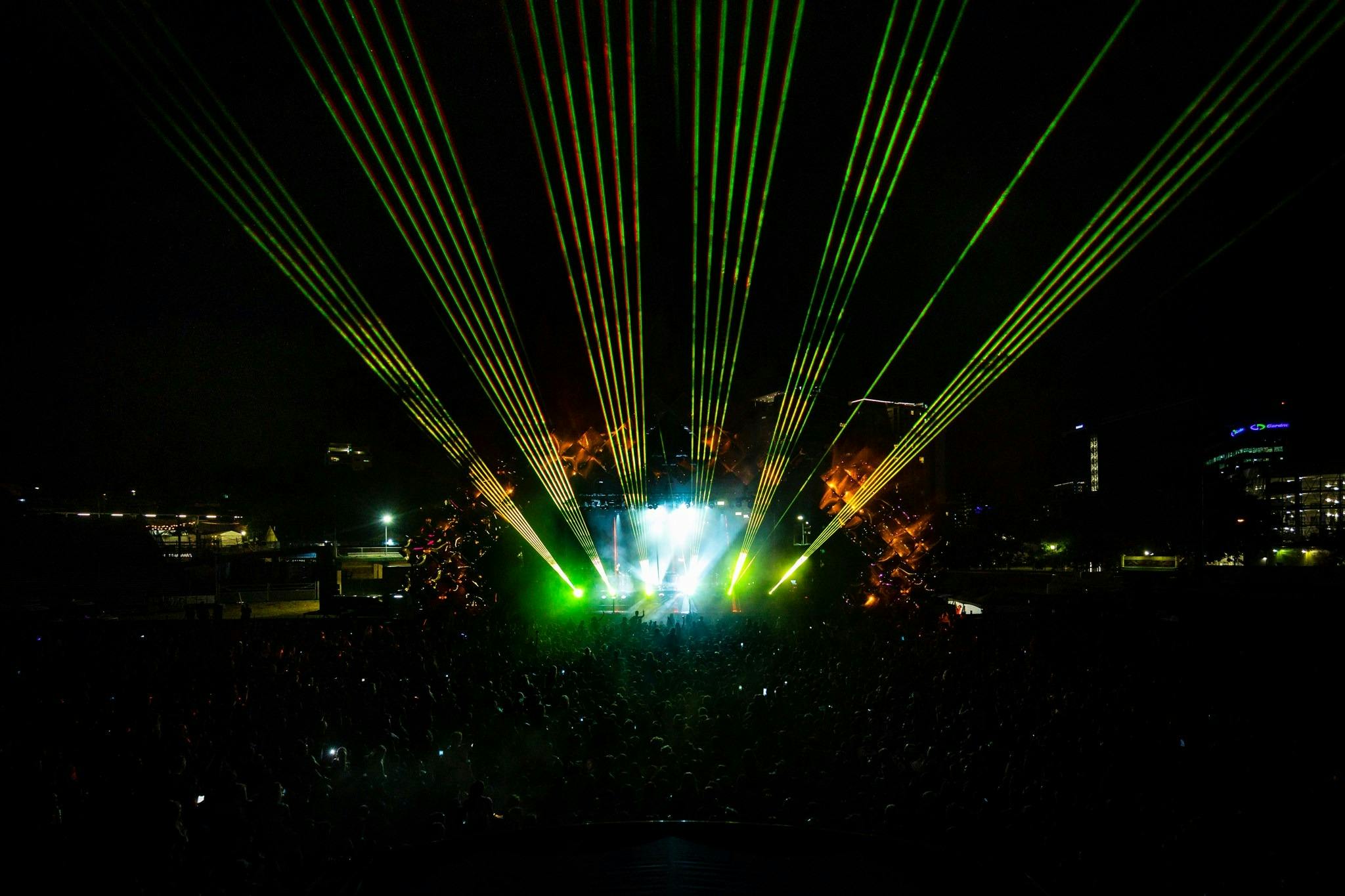 Lights shining out from a stage over a dark crowd - Wildlands 2021