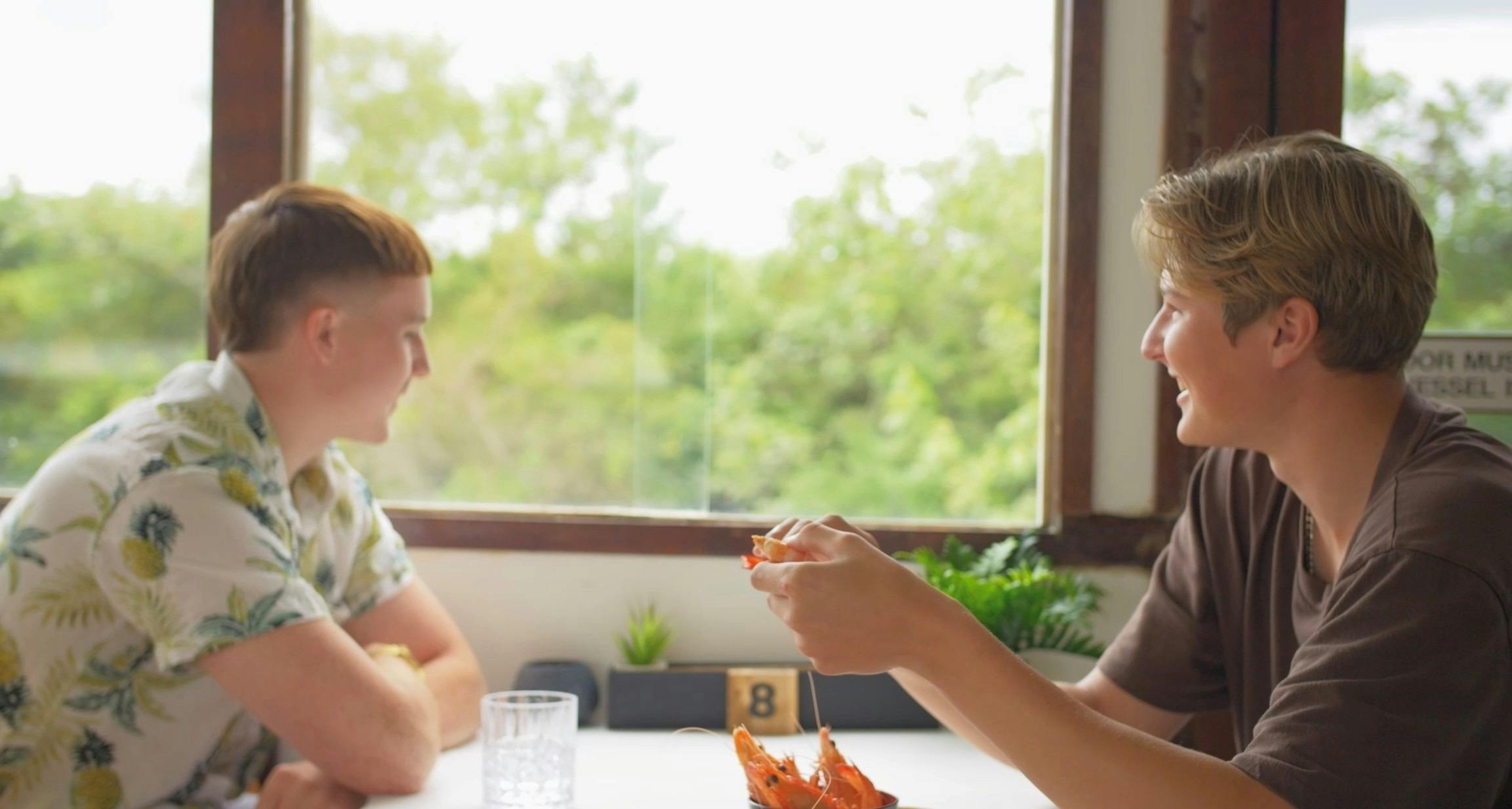 Guests sitting looking at view and eating prawns.