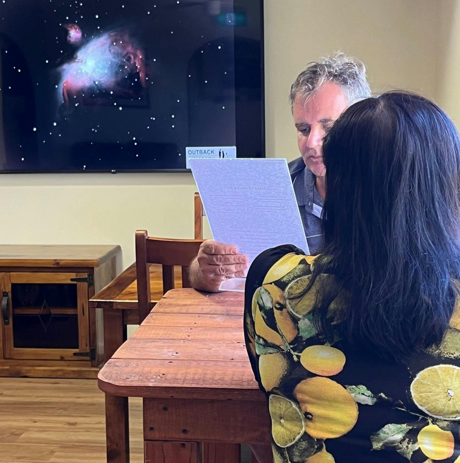 People sitting at table reading menu