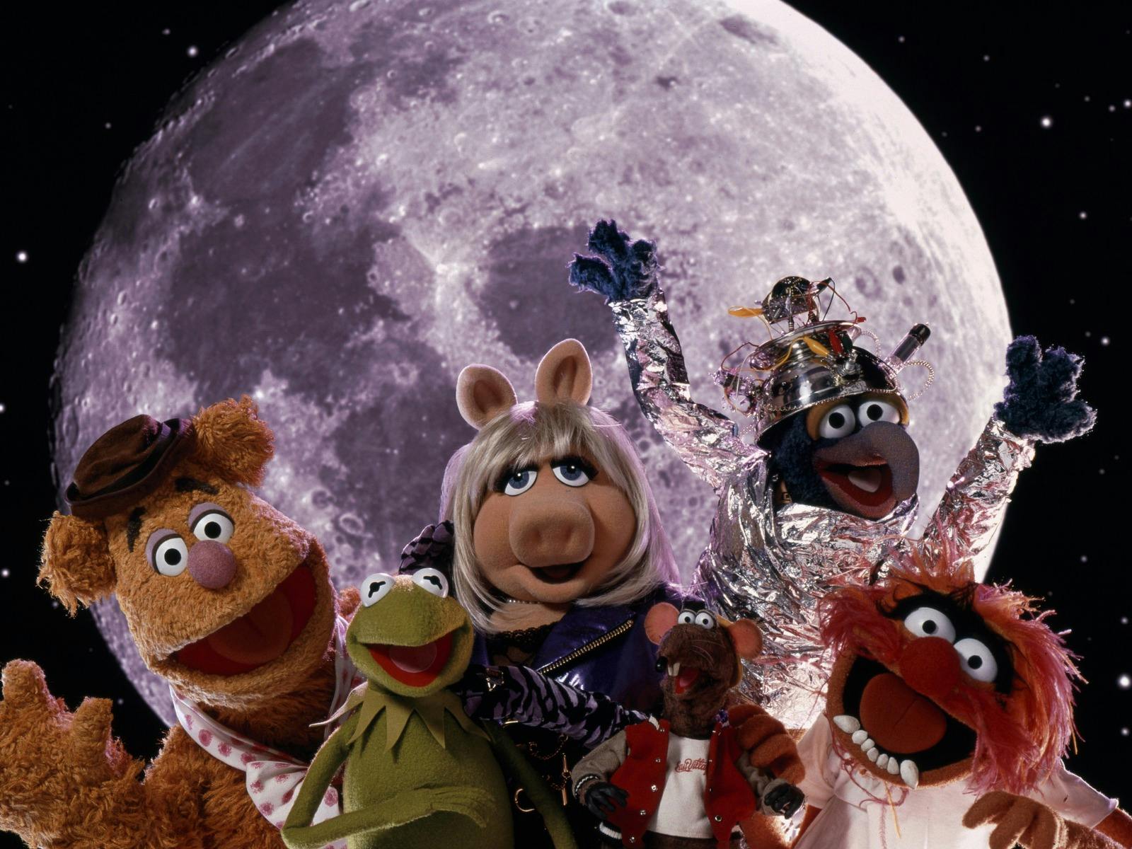 Six puppets looking excited at the camera with a planet in the background