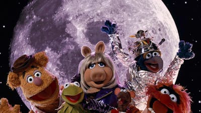 Six puppets looking excited at the camera with a planet in the background