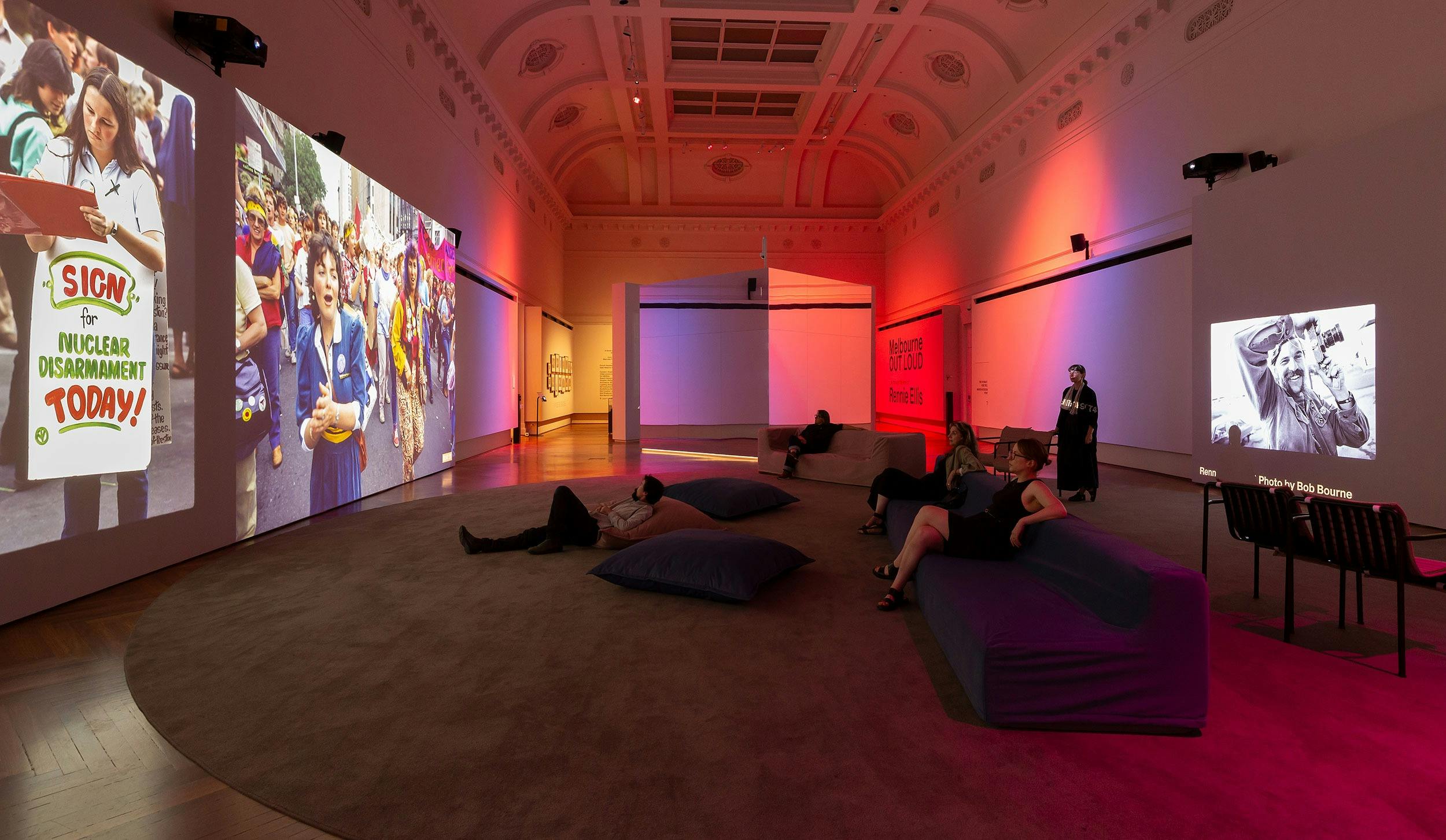 Large space full of colour with people on couches looking at screens
