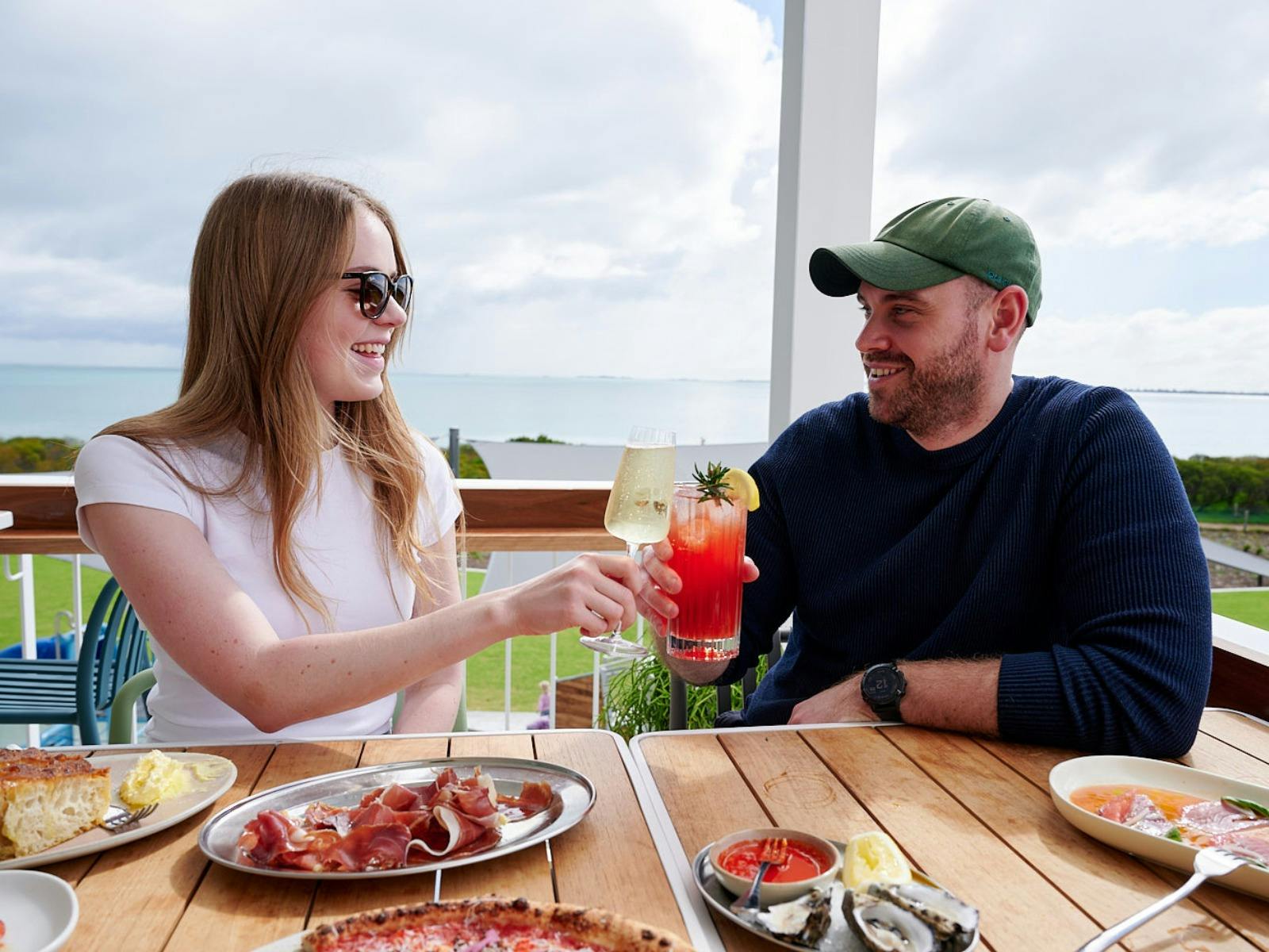 Man and woman enjoying delicious meal while overlooking Kennedy Bay