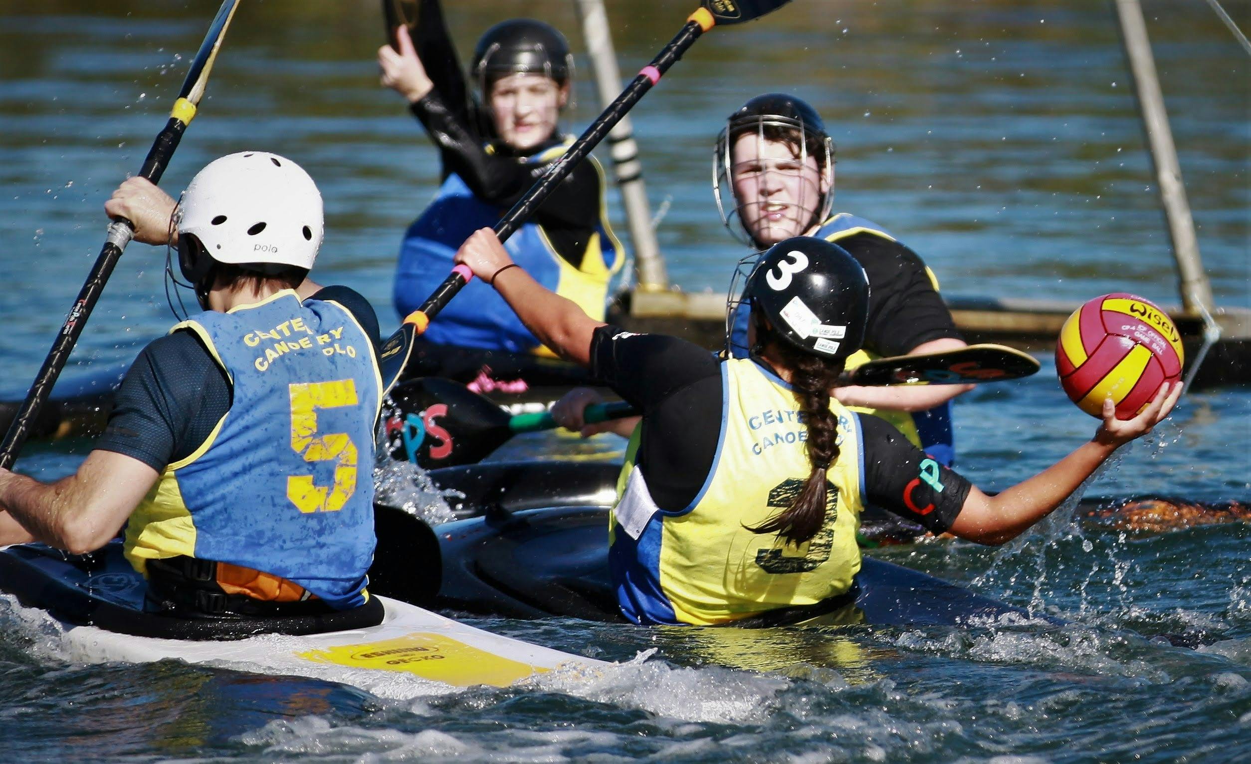 One player in goals has their paddle up, whilst the opposition is ready to shoot the ball