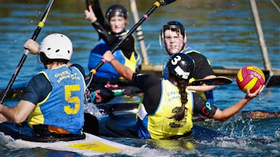 One player in goals has their paddle up, whilst the opposition is ready to shoot the ball