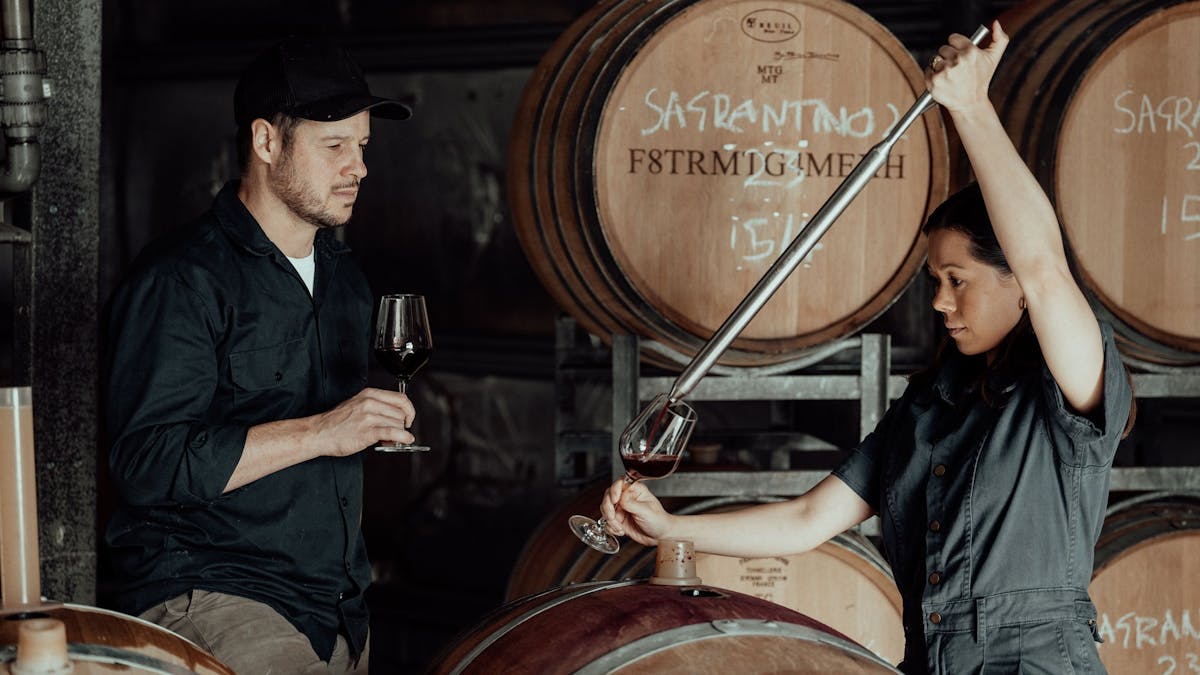 Caitlin and Nick barrel tasting some of the 2022 reds in the winery.