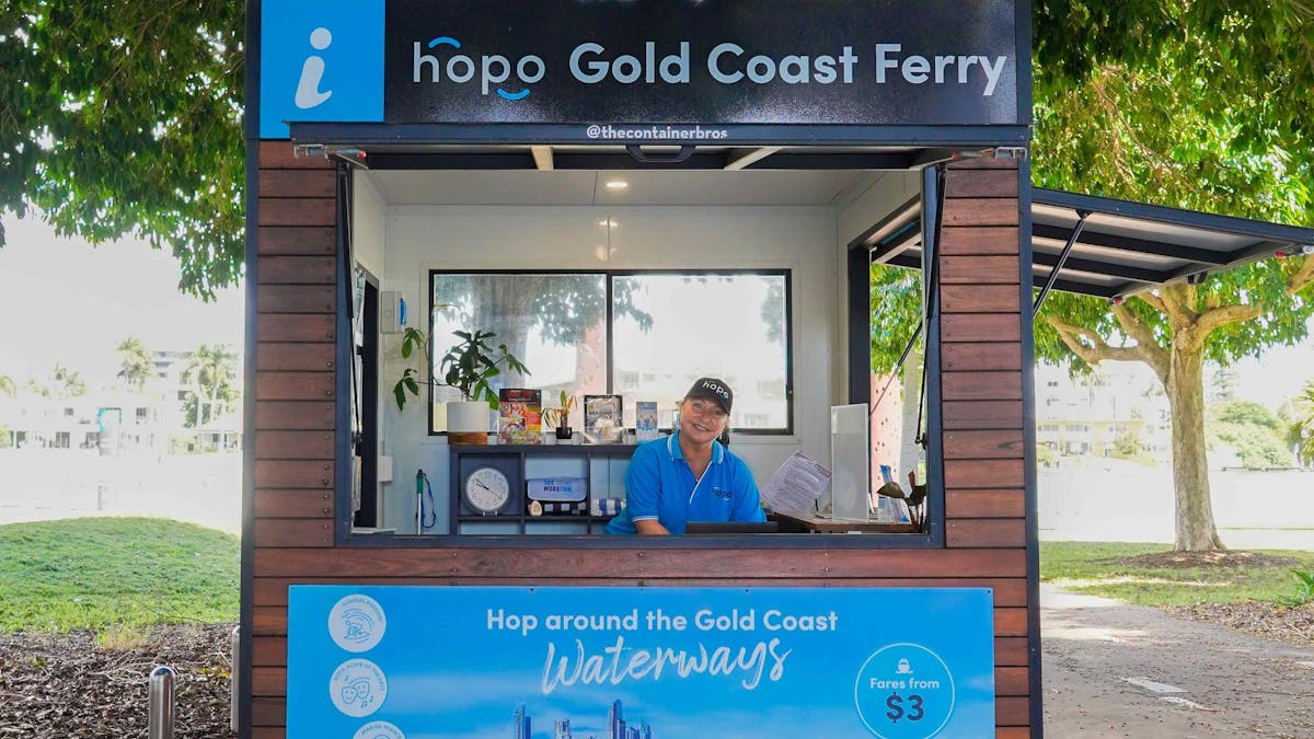 Woman in blue Hopo shirt stands inside Hopo Information Kiosk