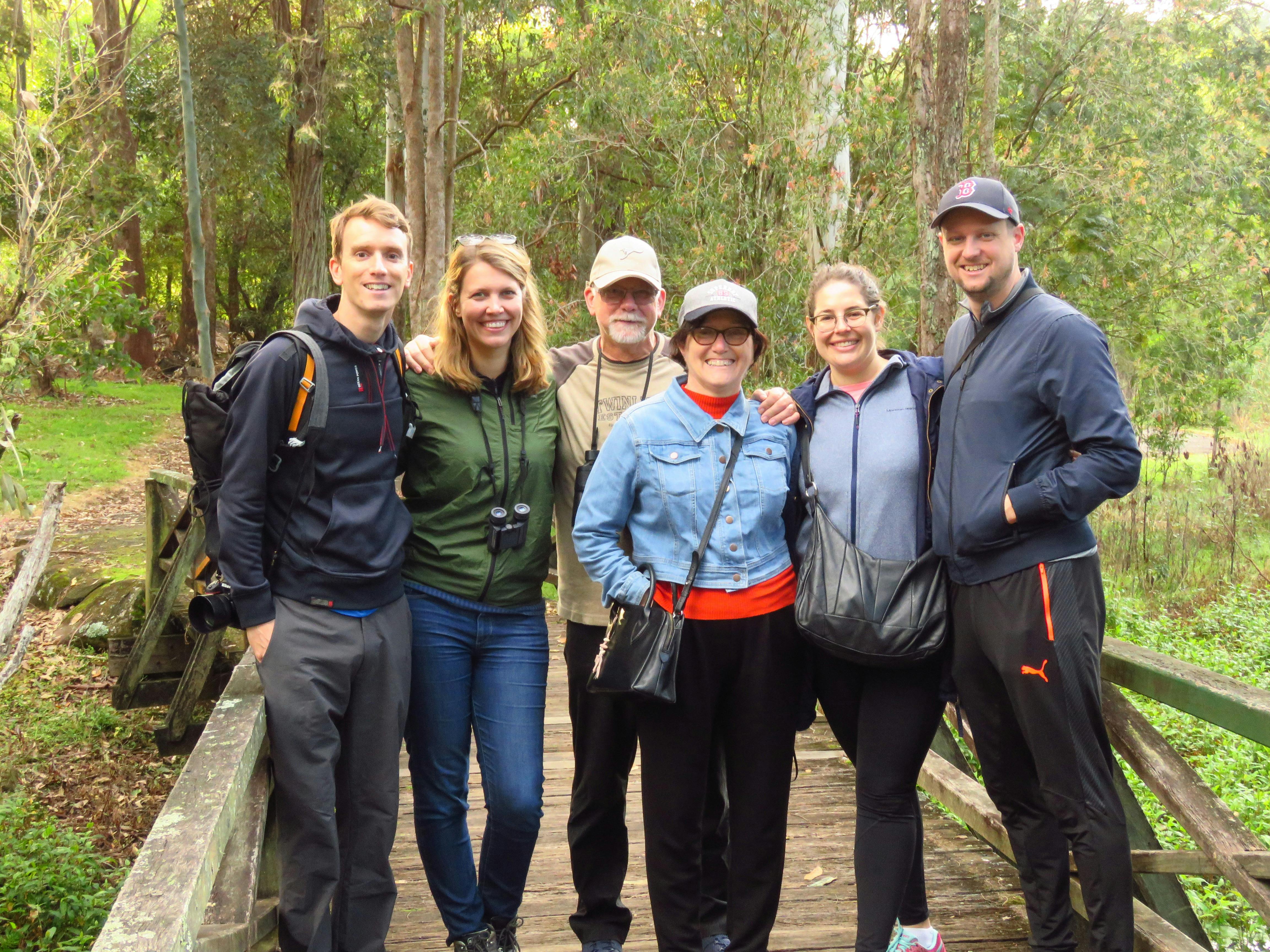A group of people smiling on a bridge while on the Platypus Walk