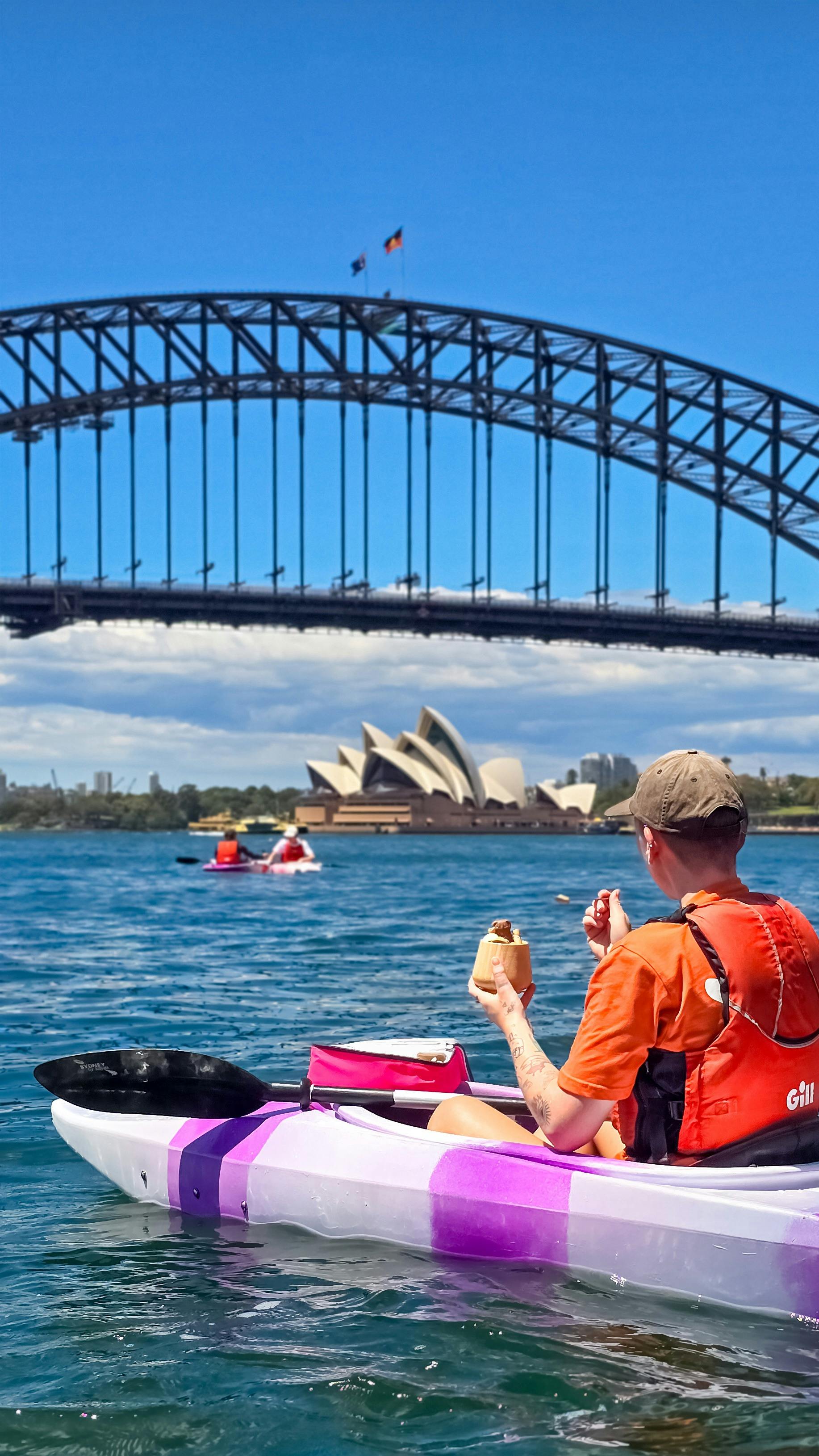 Lady eating gelato ice cream while admiring view of Sydney Harbour Bridge and the Opera House.
