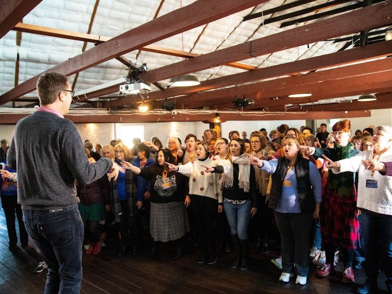 A conductor orchestrating a large group of singers