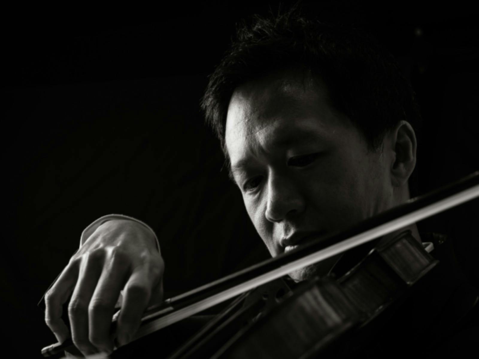 Black-and-white portrait of a violinist in profile, looking toward the light
