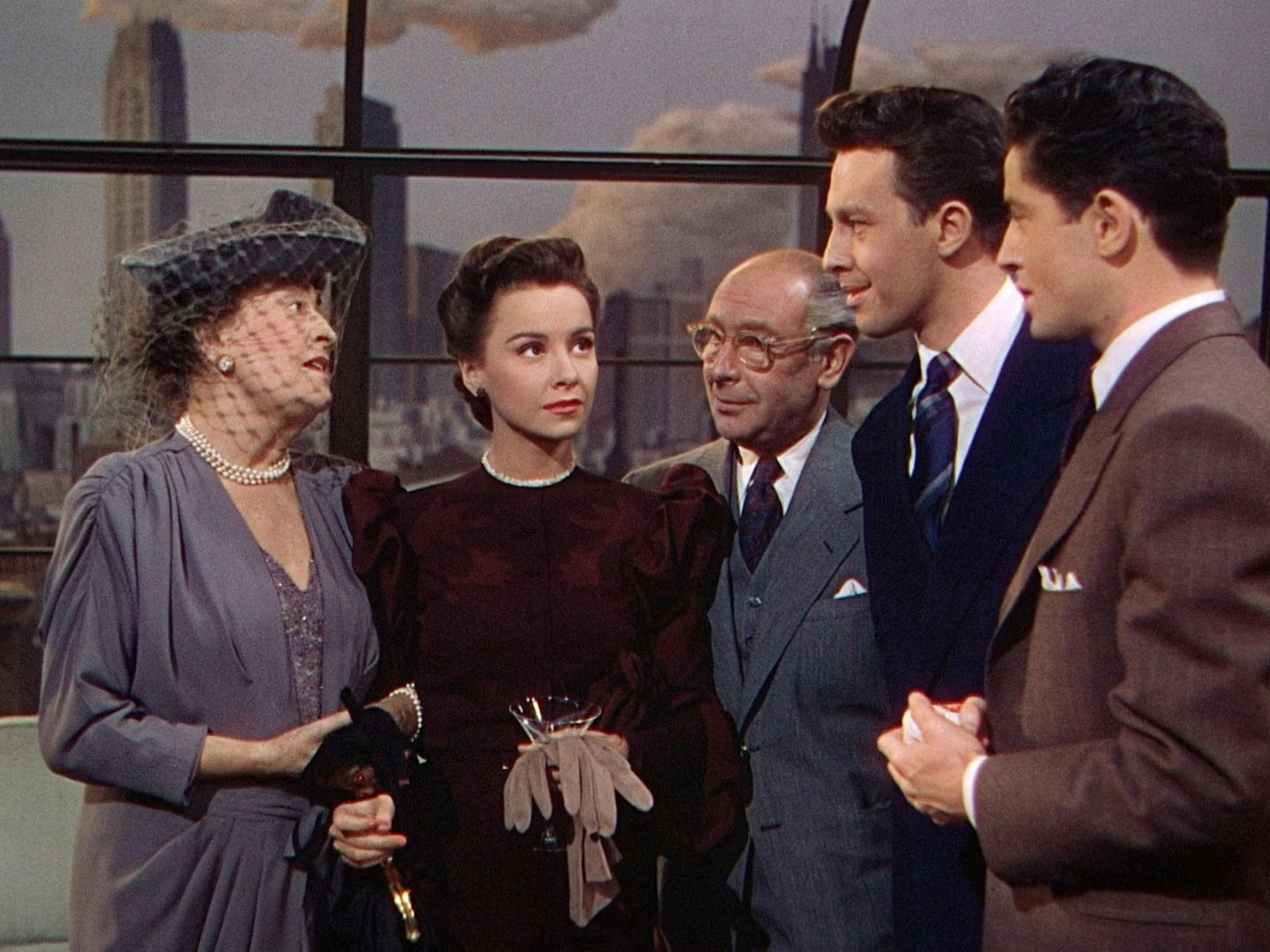 Group of five people standing in a semi circle conversing
