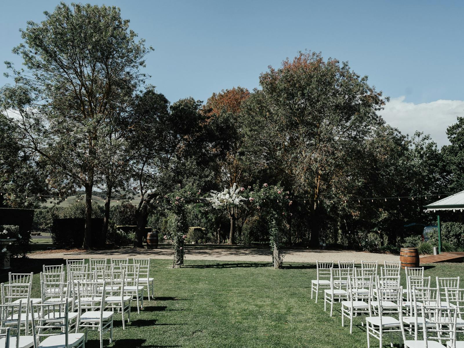 Wedding ceremony space with arbour and wedding seating set up on lawn