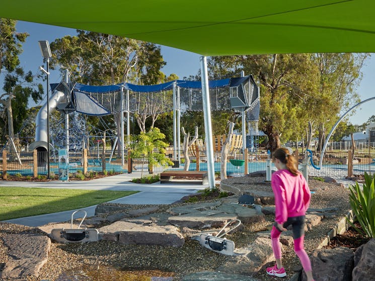 A young girl walks through a playground towards an aerial walkway at Purtle Park, Mulwala.