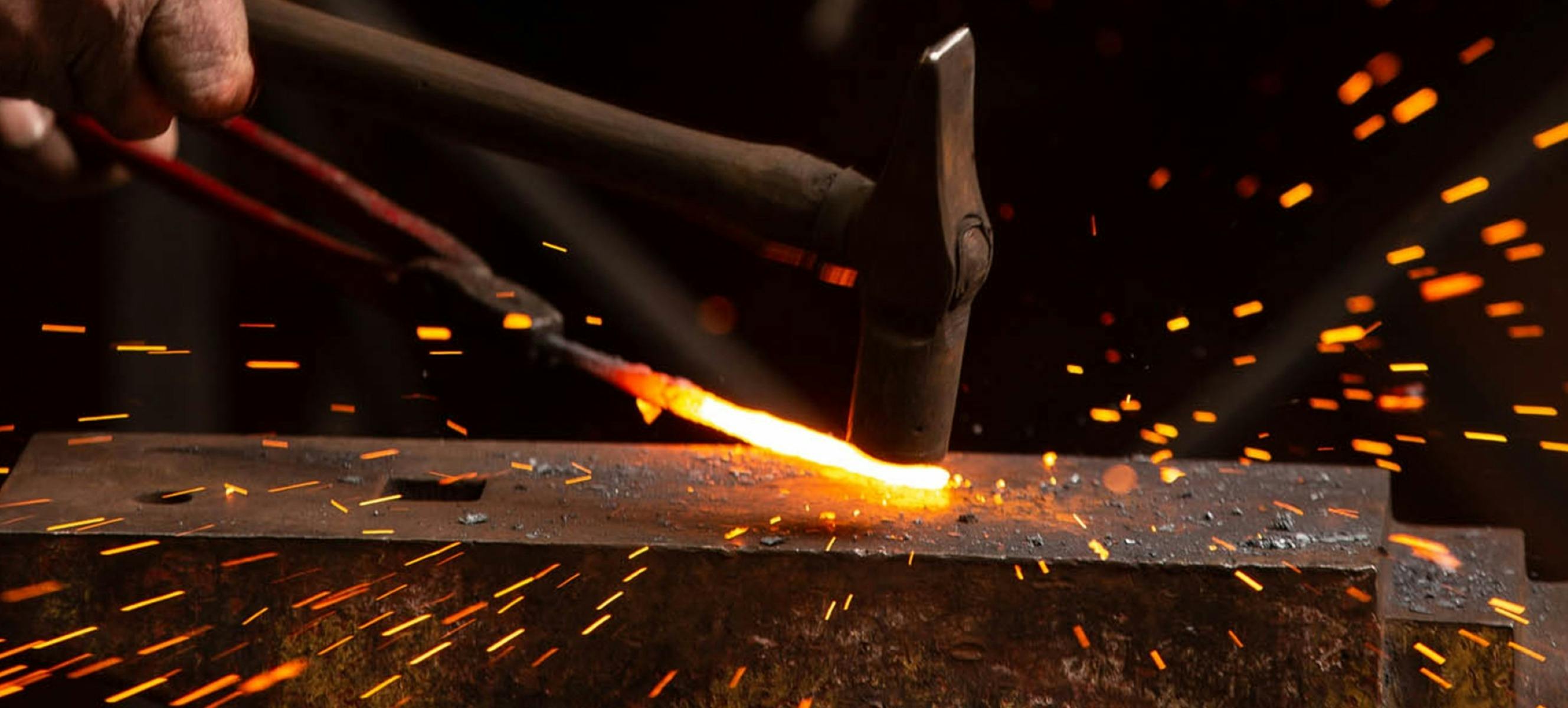 Hammer hitting metal sparks flying.