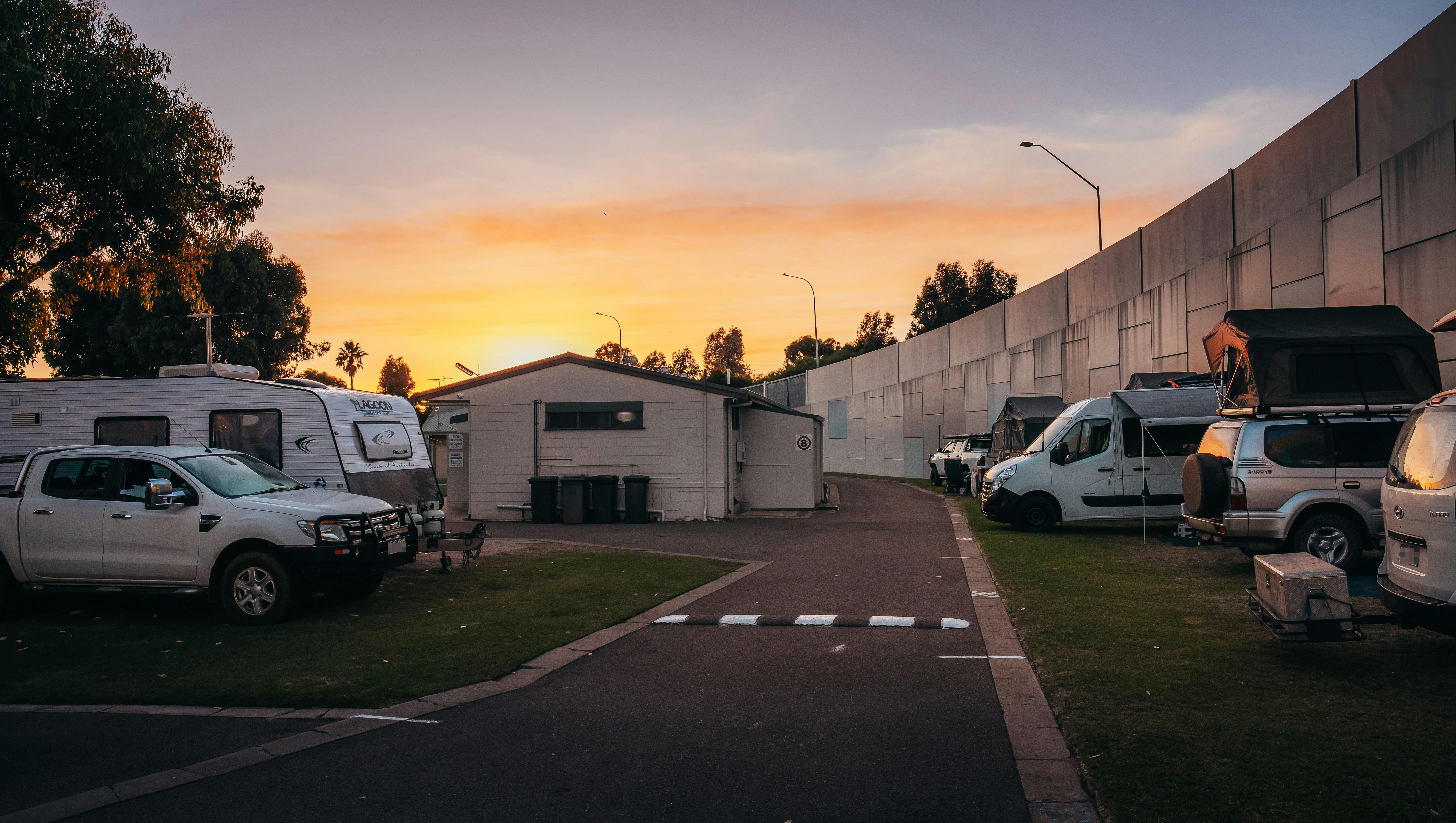 A sun sets in pink and orange over Esperance Bay Caravan Park road with sites and ablutions