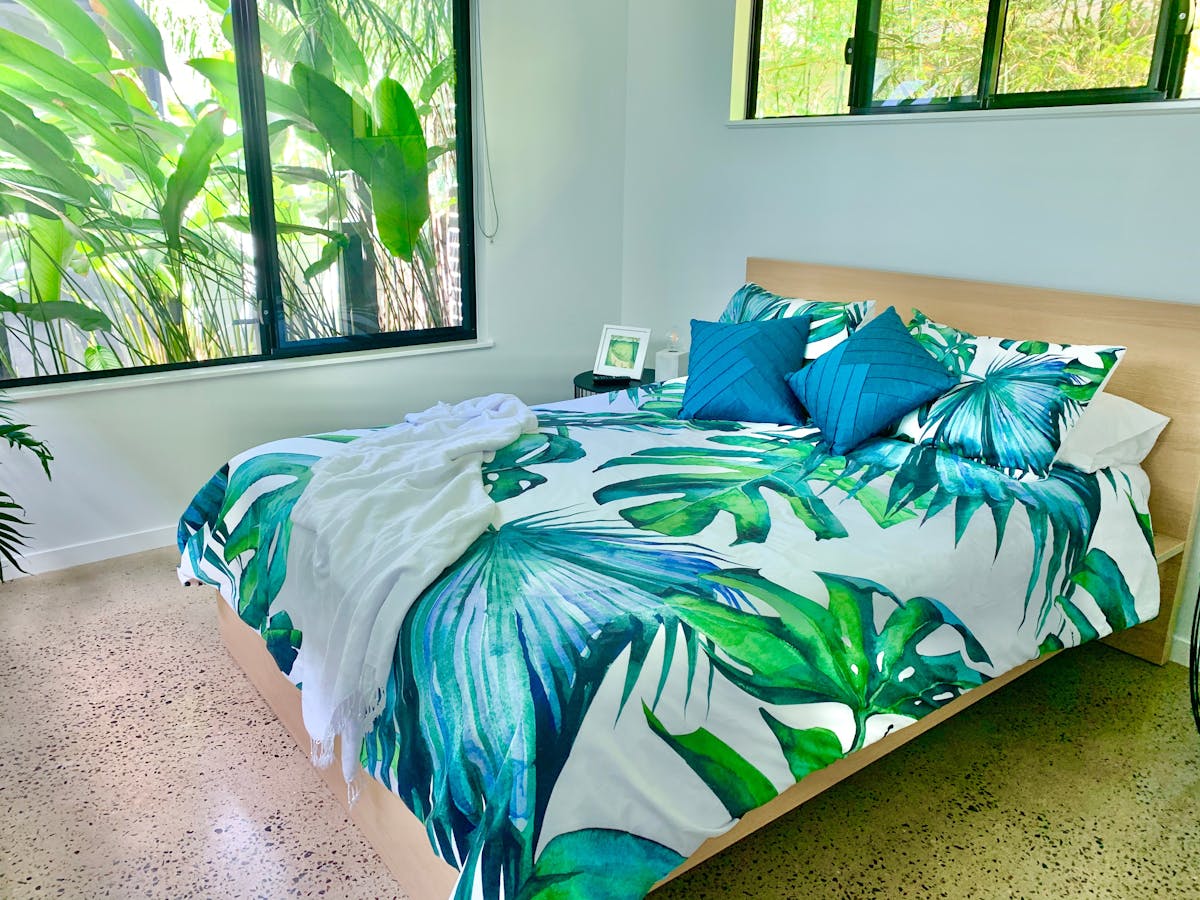 Bedroom with queen bed and windows overlooking the garden