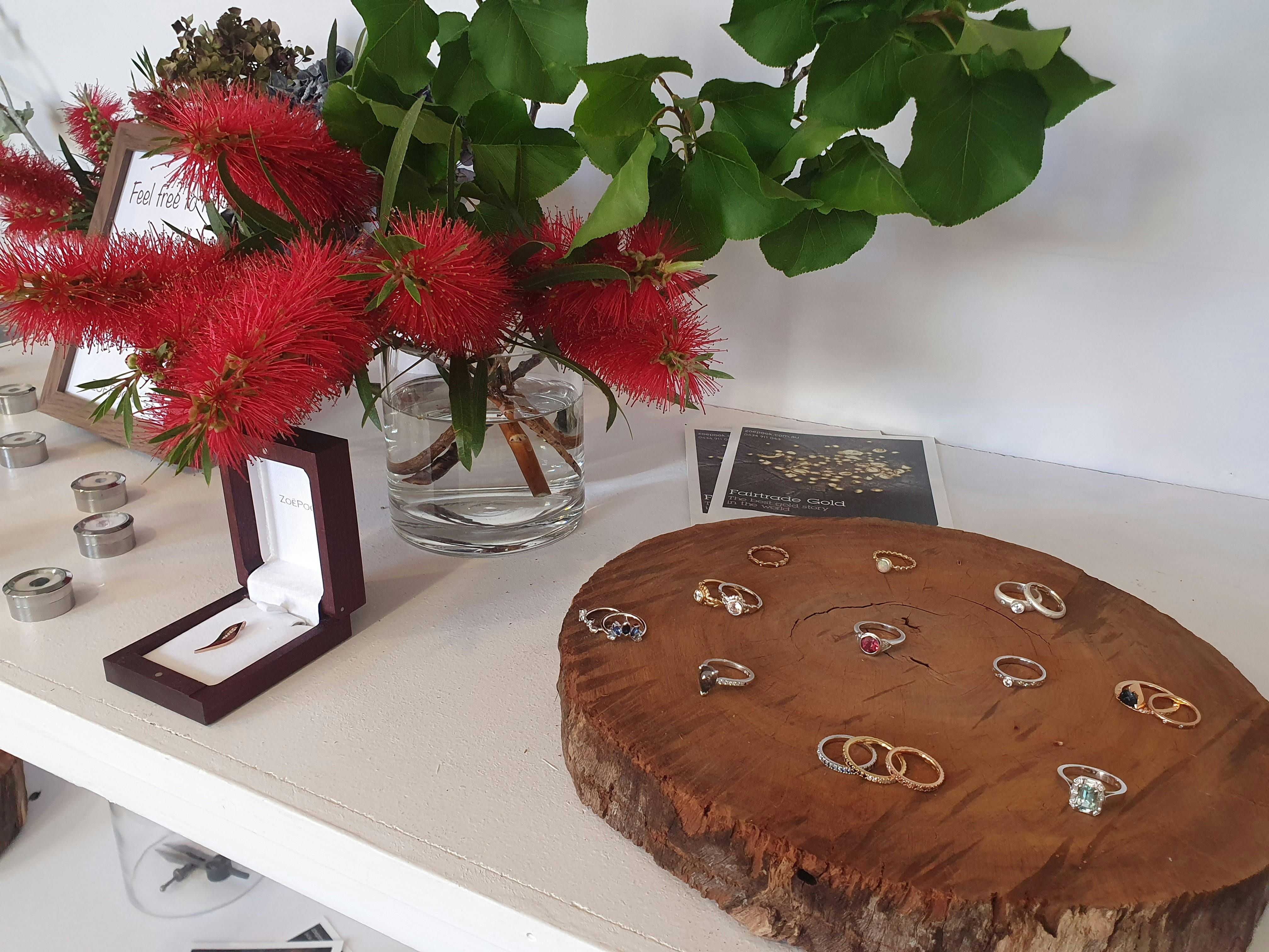 商店里，珠宝首饰摆放在木制展示架上，旁边点缀着鲜花。