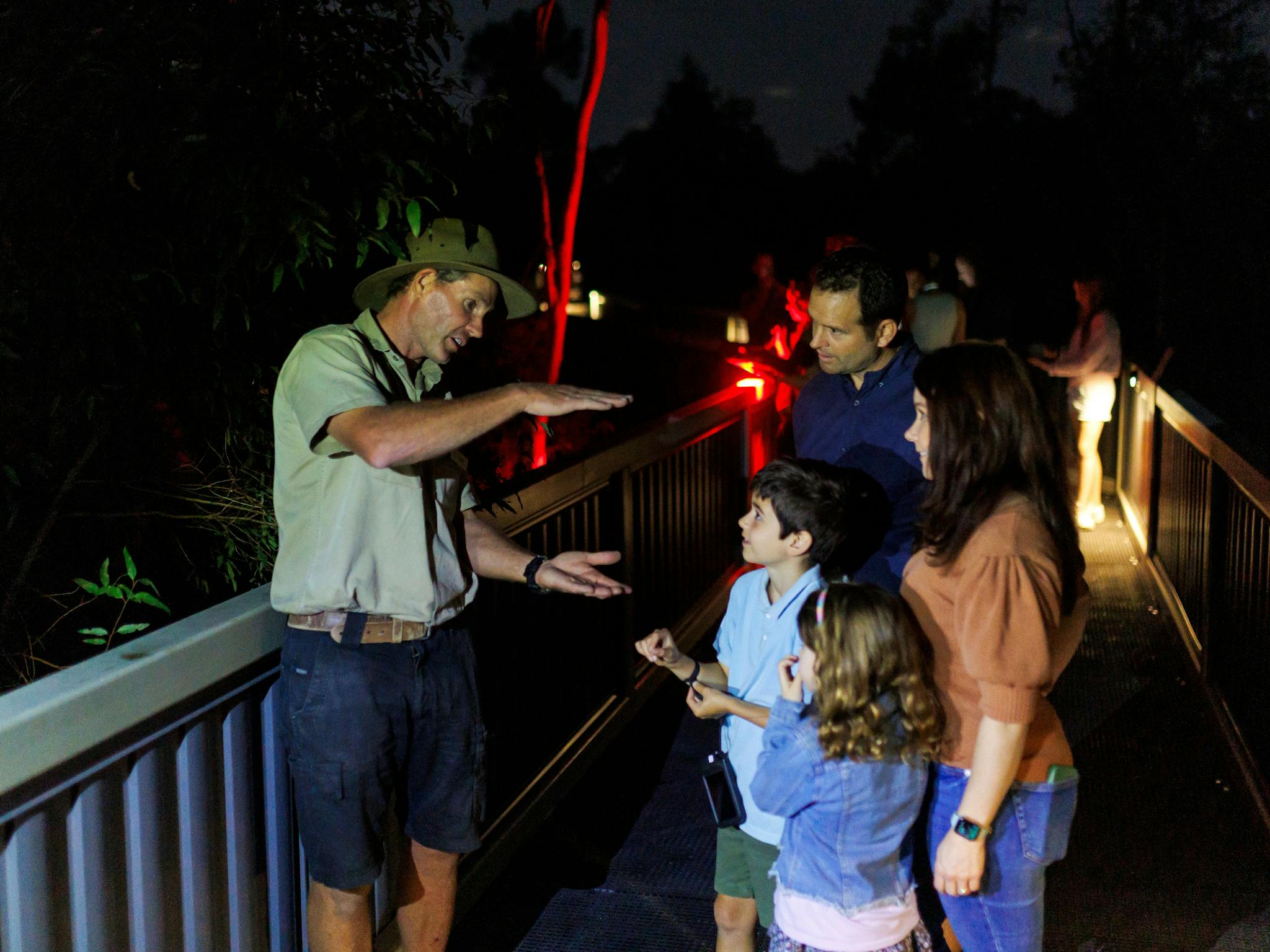 Young family with wildlife keeper learning about Australian animals at night. Young family with wildlife keeper learning about Australian animals at night.