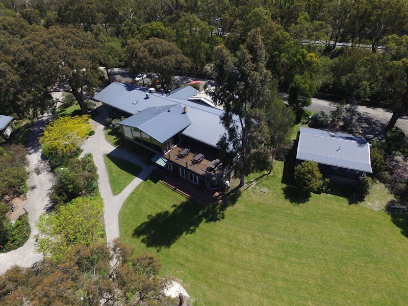 Drone photo showing Yarra Valley Estate’s buildings nestled among trees, with lawns, walking paths a