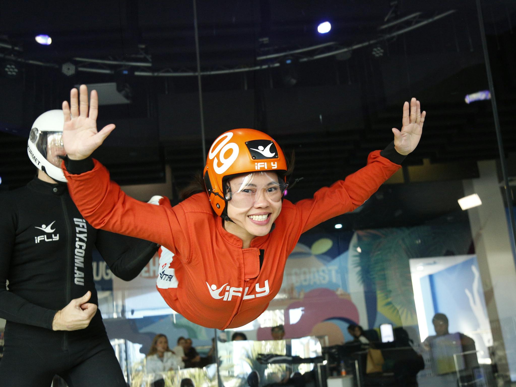 Female first time flyer in an orange suit with a massive smile. Female first time flyer in an orange suit with a massive smile.