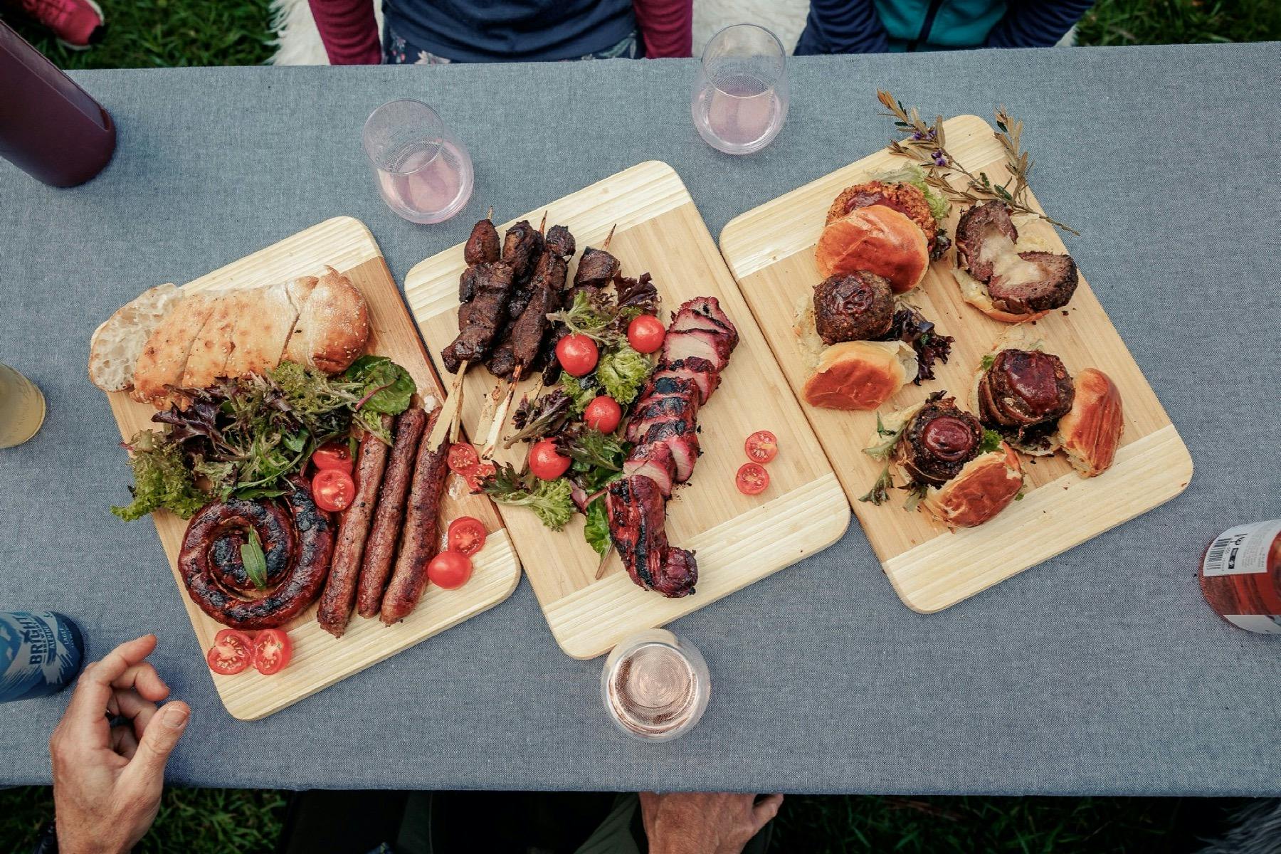 Three wooden trays with assorted grilled meats