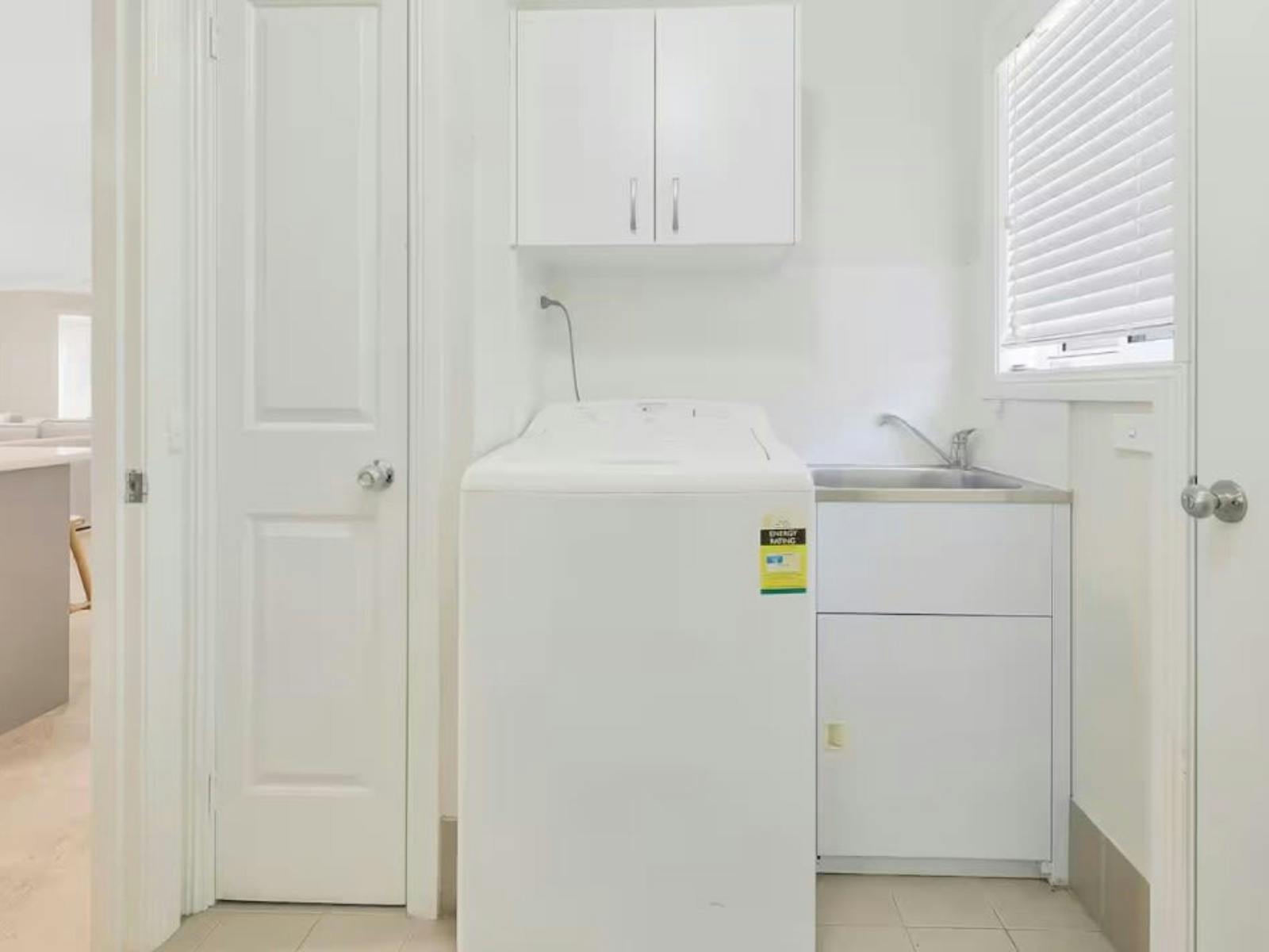 Laundry with washing machine, storage and sink