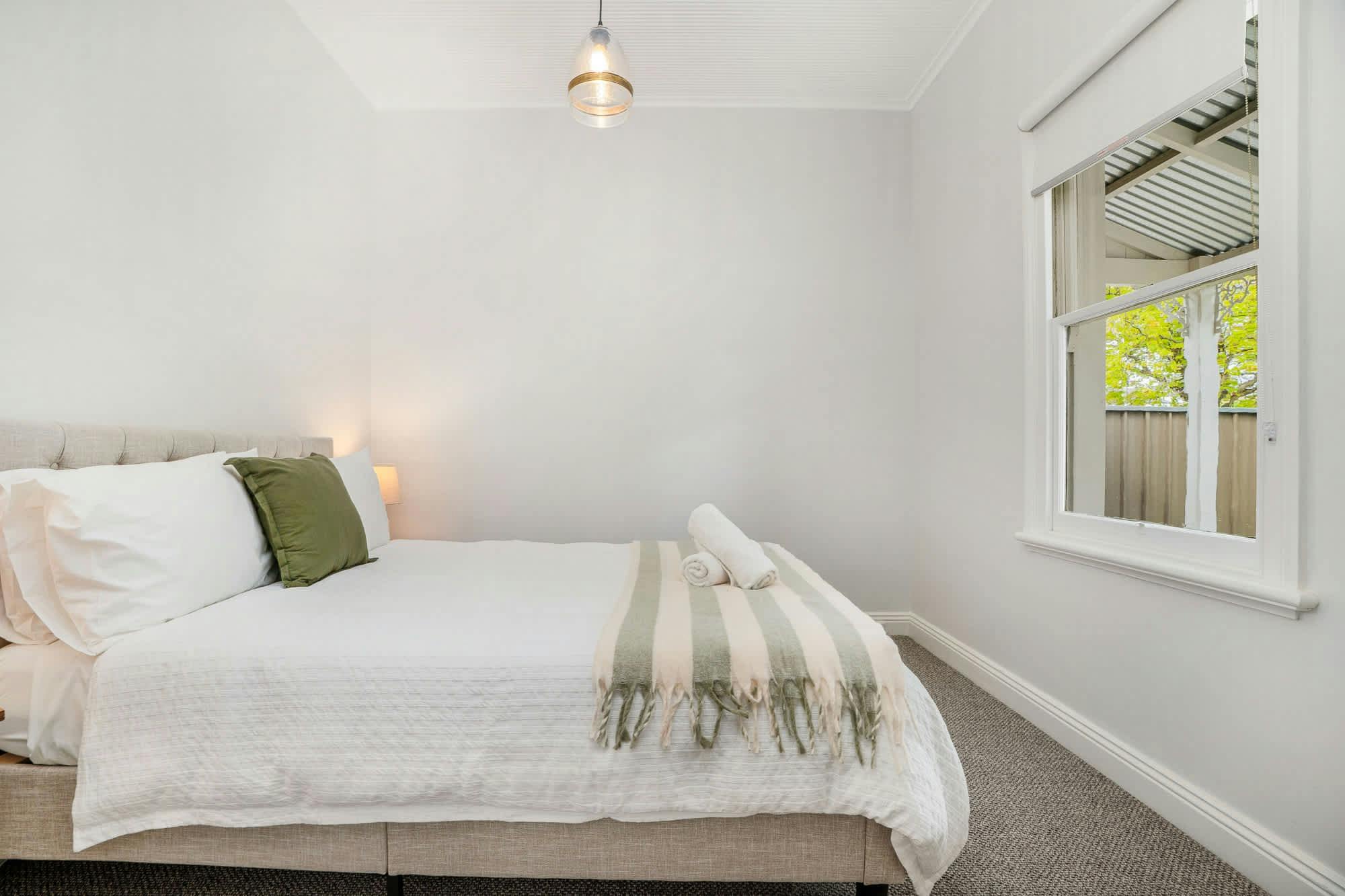 Queen bed with a view of the front garden and edward st