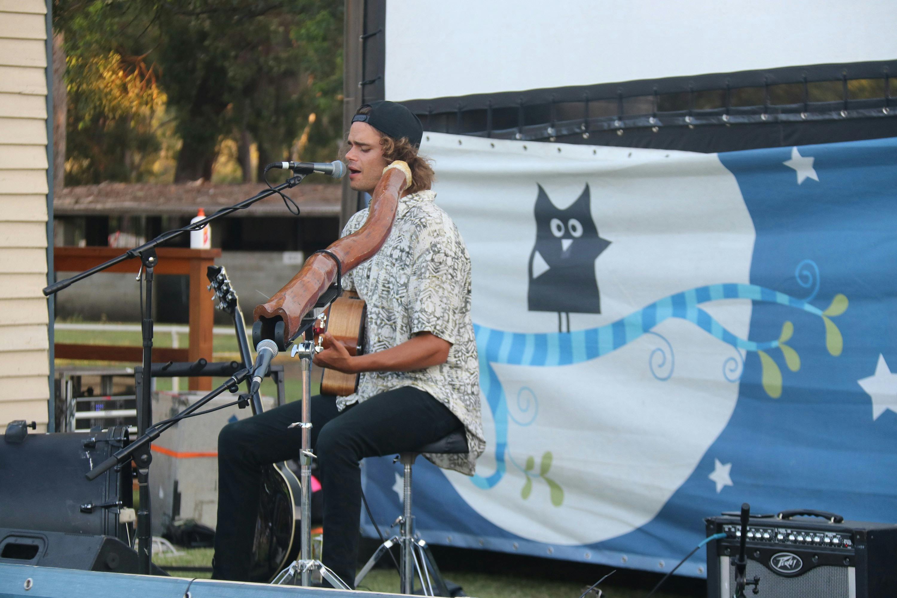 Musician sings on stage with guitar