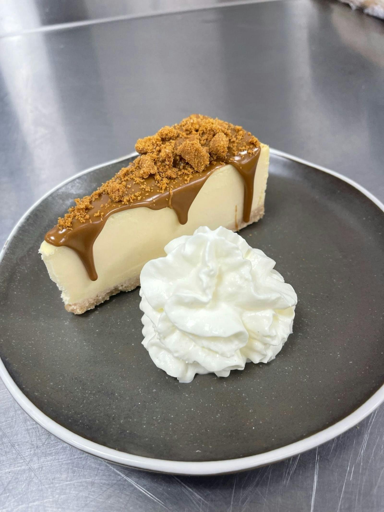 Biscoff cheesecake with a blob of fluffy whip cream.