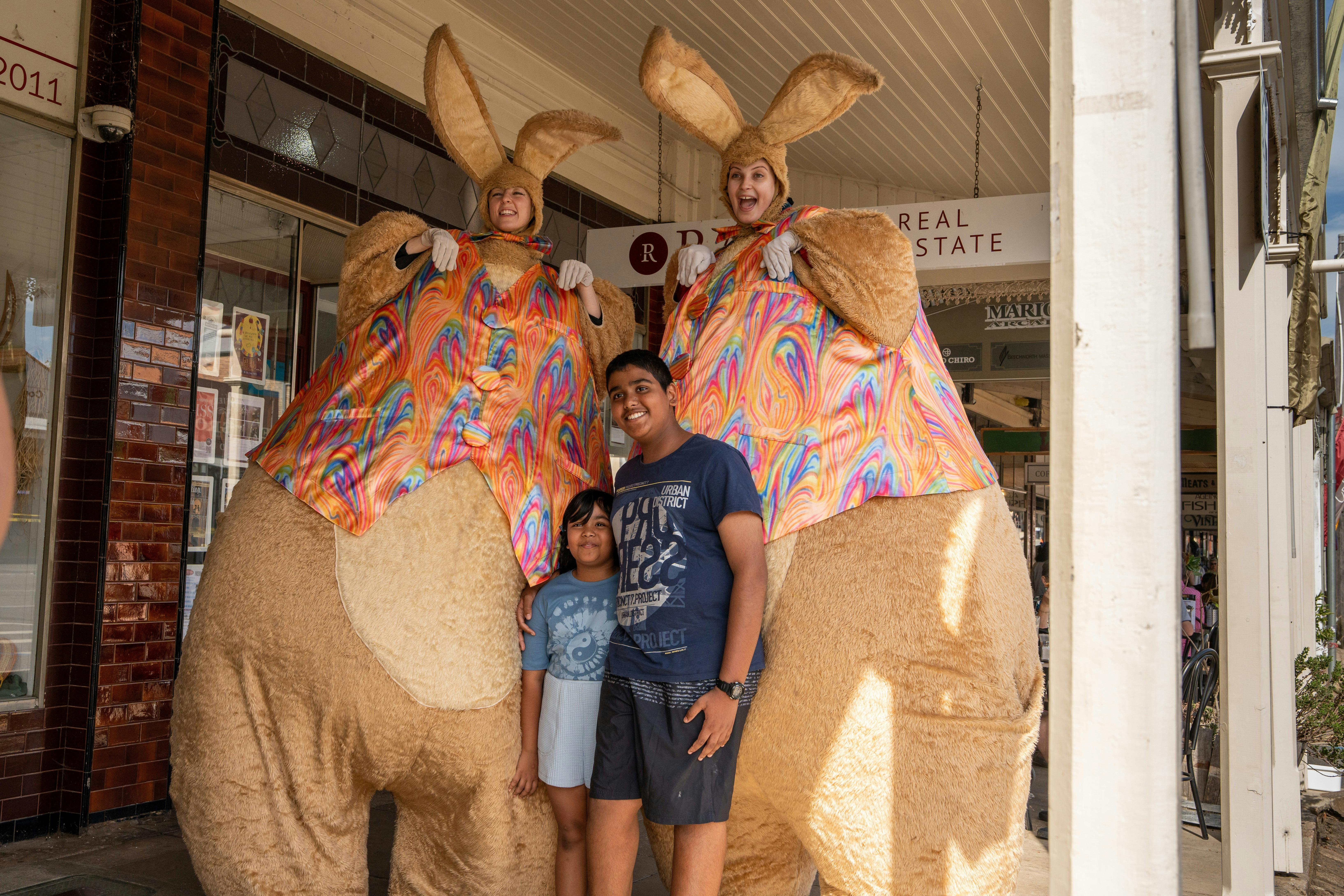 two gigantic easter bunny stilt walkers with festival goers