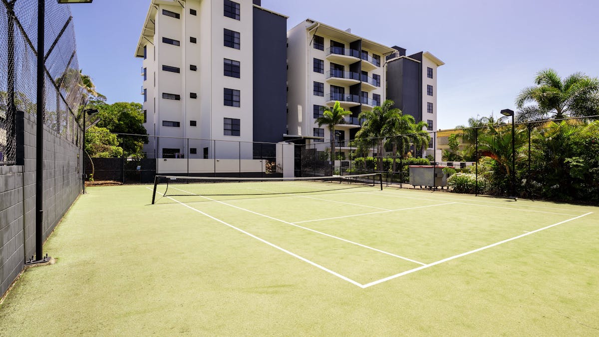 A view of the the tennis court with the apartment building  at The Bay Apartments Hervey Bay